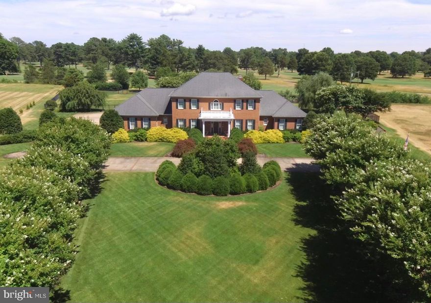 Exquisite, Custom Georgian all brick home with finished basement nestled on 2.45 acre with saltwater pool, 5 car garage, koi pond, 4 fireplaces, whole house generator and pool house all overlooking the 4th hole of the prestigious Fredericksburg Country Club. 5 bedrooms, 6.5 baths with 9,144 sq. ft. this meticulous home welcomes you with a circular driveway with intricate brick inlay, adding to its exceptional curb appeal. As you enter through the front door, you are greeted with stunning hardwood flooring and a magnificent, custom grand staircase in the foyer that exudes elegance and sophistication. This breathtaking feature sets the tone for the rest of the house, boasting custom member on member chair rail, crown molding, wainscoting and plantation shutters throughout. To the left of the staircase, you will find the formal dining room featuring a stunning chandelier adorned with Waterford crystals. On the right is the formal living room. The gourmet kitchen features custom wooden cabinetry, display cabinets, granite countertops, GE profile appliances including dual electric ovens, gas cooktop with downdraft and interchangeable grill, griddle and burners. The large kitchen island includes a separate sink creating multiple preparation areas throughout the kitchen. The kitchen overlooks the breakfast area and family room featuring the granite fireplace with gas logs. Access the 12’x24’ screen porch with porcelain flooring and ceiling fans overlooking the pool. The half bath is easily accessible for guest and includes a beautiful wooden vanity with Kohler artist edition sink. The luxurious primary bedroom retreat, complete with a spacious en-suite bathroom and walk-in closet is located on the main level and includes elegant cove lighting, gas fireplace and French doors leading to the Primary Bath. The primary bathroom features sliding doors leading to the 16’x 30’ deck overlooking the pool and includes a custom dual vanity with ample storage, ceramic tile, garden tub and tile shower with glass door. Completing the main level is the oversized laundry room with built in cabinetry and sink, and a closet to hang and dry clothing. The 3-car garage (35’x50’) includes built in cabinetry and a workstation.  The spacious second floor includes two luxurious ensuite bedrooms and two additional bedrooms sharing a charming Jack and Jill bathroom all with carpet and walk-in closets. The finished, walk-up basement is sure to impress with its theater room and wet bar. The area is perfect for entertaining guests or enjoying a cozy night in with your family by the wood burning fireplace enclosed with built in book shelving. 3 utility rooms make it convenient to keep your seasonal decor organized and include industrial metal shelving. A separate cedar closet is perfect for storing off season clothing. Moving outside, the lush, fenced backyard offers plenty of space for outdoor gatherings. Stay cool in the summer with the 19’x40’ saltwater pool and soak after a long day in the 6’x8’ integral hot tub. The beautiful pool house includes a wet bar with wine rack, a full bathroom and plenty of space to entertain guests. In addition, the 2-car garage is available to store lawn equipment and tools. A koi pond in the backyard creates a serene and peaceful environment. Completing the back yard is the fenced garden. Some additional features of the home include a 45-kw whole-house generator, culligan water softener, and an irrigation system fueled by its own 300’ well. This home truly embodies luxury living at its finest. With its prime location next to the Fredericksburg County Club, you'll enjoy endless opportunities to tee off whenever you please. Don't miss out on the opportunity to make this impeccable residence your own.