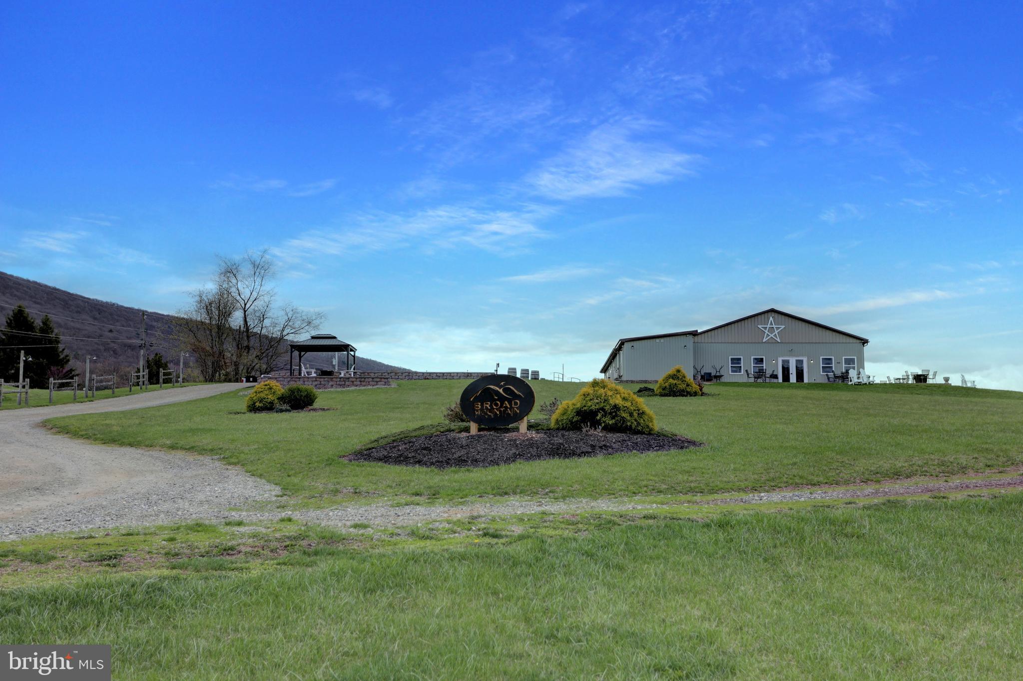Attention Vintners, Wine-Growers, Event Managers, Horticulturists, Farmers, and even Homeowners alike! Discover the serenity of this 26-acre land property nestled under Broad Mountain in Dauphin County. Endless possibilities await you to tailor this property for your own passionate business such as a winery, event space, service business, crop producing farm, or even a home, as there is no zoning in Jackson Township. See the success in your own entrepreneurship when you purchase this one-of-a-kind property in the tranquil countryside of Halifax, PA boasting 4 buildings in total, all built from 2002-2022 with a refined, mature 5000 vine vineyards on approximately 5 acres with room to expand to approximately 10+ more acres of crops. The 3200+ sqft Venue Space is tastefully designed and meticulously cared for that was built new less than 10 years ago with beautiful concrete-stained floors, tasting room, hosting room, private side room, public baths, and a back-of-house area. This building overlooks the vineyard and mountain with a wrap-around patio that can accommodate up to 140 guests while overlooking the vineyard, which is laid out and sets the stage for a great ambiance for any weddings or special occasions that you book. Additional air-conditioned buildings include a top-of-the-line 4158 sqft Production Facility with separated office and bath, a 1392 sqft Product Storage Facility, and an 1834 sqft Multi-Functional Equipment Facility. There are 4 buildings in total, 2 wells, 2 septic systems, oversized parking lots, cultured stone lanes to all facilities, a gazebo, and post and rail fencing adorned light at night! Interested in the established wine business? Currently, Broad Mountain Vineyard is part of the PA Wine Trails, has retail sales within PLCB stores, wholesale large Grocery Chains contracts in the Northeast, and the winery produces over 35 varieties of wines. This sale does not include the current operational business of Broad Mountain Vineyard Winery & Cidery, contracts, inventory, or equipment, unless interested, then it could be sold separately in addition to the real estate property. Agents see additional documents for more information and plans. Call today to have your own personal tour and decide for yourself if this dream property is for you!