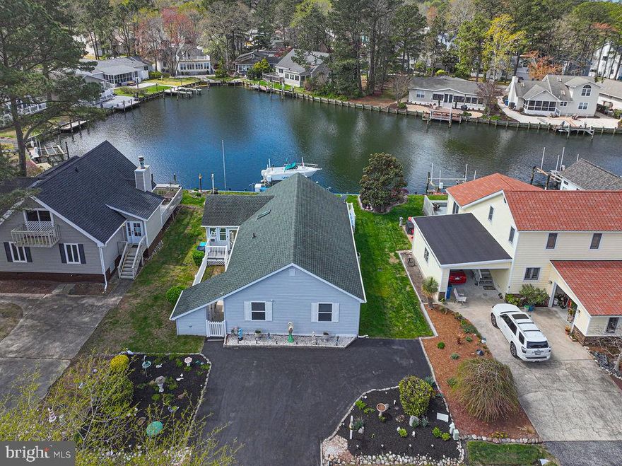 Welcome to waterfront living at its best in the sought-after Teal Bay section of Ocean Pines! This adorable, low-maintenance single-story home is perfectly positioned along a wide, lagoon-style canal—offering peaceful water views and easy boating access to the St Martin River and the back bays of Ocean City.  Lovingly cared for by the same owners for 30 years, this 3-bedroom, 2-bath home is truly move-in ready and comes furnished including all décor, making it the perfect turnkey coastal retreat or investment opportunity. Inside, you will find a light-filled great room with vaulted ceilings, an open kitchen and dining area, a lovely gas fireplace, and lovely tinted windows that beautifully frame the water while reducing glare.  LVP flooring adds to the easy-care lifestyle.  The four season sunroom allows for great possibilities - use it to expand your entertaining space since it includes a second refrigerator, or use it as an office or an overflow bedroom!  Step outside to a huge waterfront deck (from either the great room or the sunroom) —ideal for entertaining or relaxing—plus a private dock and 8,000 lb boat lift for exciting days on the water. Pet lovers will appreciate the fenced front yard and gated deck.  Additional updates include a fully encapsulated crawlspace (just 2 years old) with sump pump and humidity gauge, and brand-new ductwork throughout the home—offering peace of mind for years to come. Storage is not an issue here – with a large storage shed (where you will find a third refrigerator) and an attic with a full floor.  This home has been very well maintained,  is impeccably clean, and is ready for you to enjoy the upcoming season!  Ocean Pines is the Eastern Shore’s premier community, where you will enjoy low HOA fees and incredible amenities including five pools (one indoor), a Robert Trent Jones Championship golf course, racquet center with pickleball and tennis, yacht club and marina, beach club, parks, and walking trails. Just minutes to historic Berlin and a short drive or boat ride to Ocean City and Assateague beaches. This is coastal living done right—don’t miss your chance to own this charming waterfront gem!
