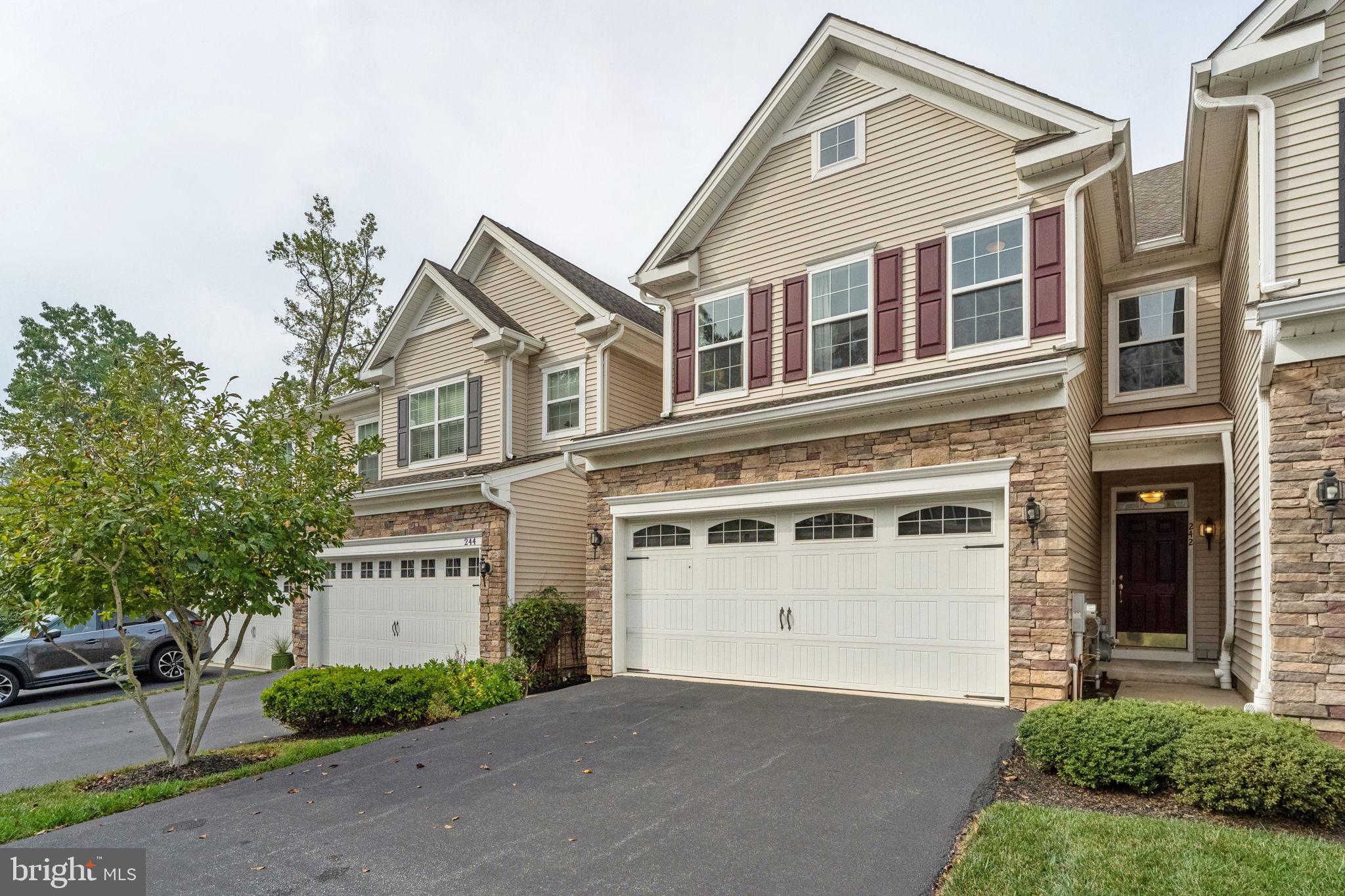 Still has that new house smell! This 2016 D.R. Horton townhome in The Grande at Muirwood Hill has technically existed for 10 years, but here’s the twist: it’s never been lived in. That’s right—no shoes on the floors, no pots on the burners, not even a pizza box in the fridge. Everything here is spotless, untouched, and waiting for its very first chapter. 242 Clermont backs to the beautiful wooded area that provides total privacy from inside. Your views are of tree tops, occasional wildlife, and sunsets!
The covered front entry opens to dark coffee bean hardwoods that stretch through every room (except the tiled baths). Wide-open spaces mean you’ll never feel cramped—living, dining, and a gleaming eat-in kitchen all flow together. The kitchen is a showstopper: GE appliances (5-burner gas cooktop, wall oven, French door fridge), tall soft-close cabinets, granite counters, and an island breakfast bar. Even CSI wouldn’t find a trace of cooking here. Off the kitchen, sliders lead to a full-width deck overlooking the back. A black slate-surround gas fireplace adds a cozy focal point.
Upstairs, the turned staircase with iron railings makes a dramatic entrance to three bedrooms, including a spacious primary suite with tray ceiling, recessed lighting, large walk-in closet, and en suite bath with dual sinks, corner tub (no bubbles have bubbled here), and walk-in shower. The hall bath also offers double sinks, while the laundry room and oversized linen closet keep things practical. The laundry room has new GE front loader washer and dryer, cabinets and a utility sink.
The finished basement adds 1,000+ sq ft with light Berber carpet, built-in bar, living area, bedroom, full bath, storage, and walkout access. High ceilings and recessed lights keep it bright and inviting. Add in a 2-car garage (with brand-new opener), driveway parking for two more, and a prime location just one mile to Whole Foods, Acme, Kilwins, Ulta, and endless restaurants, and you’ve got the best of suburban living. Bonus: fancy furniture was purchased new for this home and has never been used—negotiable with the sale. The is the definition of turnkey!