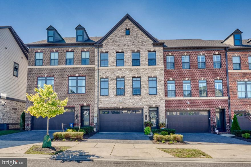 Greenleigh at Crossroads is the only new Baltimore County urban village of Luxury Townhomes near commuter routes offering great amenities perfect for an active lifestyle! The Andrew Carnegie design features a 2-car front entry garage. 3,120 square feet of living space on 3 levels boasting modern features and finishes throughout. A bright and open gourmet kitchen. A large dining room and the living room are found just off the kitchen on either side. Upstairs includes 2 large bedrooms, 1 office/bedroom, and 2 full baths. The luxurious primary bedroom features a bank of windows, new hardwood floors and a dual walk-in closet. A finished Recreation Room offers added living space that completes this luxury townhome. The house features Custom Plantation blinds in the Dining room, the upper-level bedrooms, and the finished lower Recreational/Family Room. Scenic view of trees from the deck. The neighborhood features walk-to shops, a pool, a resort-style clubhouse, a fitness center,  trails, a playground, and more. The property is one of the closest properties to the pool/community center. Located near the dog park. The property is part of Phase I whereby all construction has been completed.