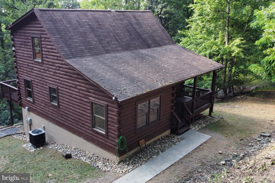 Nestled privately among trees on a tranquil 2.6 acre lot, enjoy amazing sunsets and tree-house-like views from this updated, move-in-ready 3 bedroom/3 bathroom FULLY LOG home located less than 70 miles from DC! Feel like you’re on a permanent vacation in this nearly 2,400 finished sqft showplace that’s less than 5 minutes from the community pool/clubhouse/tennis/basketball courts (in the gated community of High Knob which is located about 2 miles from I-66 exit 13).  Enjoy a delightful open vaulted floor plan with a myriad of recent upgrades. FEATURES TO NOTE: The main & upper floors are mostly all log (including refinished pine wood floors) and the lower level has a 2nd primarily suite (perfect for a potential in-law apartment) w/ level walk-out access under the rear deck (just stained!) that is attached to a path to the large driveway (plenty of room for 3 cars to park and turn around on the paved area and more cars could easily be parked alongside). Enjoy the vaulted 2-story great room with stone gas fireplace, upper open loft, a spacious eat-in kitchen, covered front porch (could easily be screened) and gigantic rear deck along the entire rear of the home.  Flooring throughout is entirely wood and ceramic tile, most of the home has been freshly painted and many fixtures have just been replaced (inside and out).  From stainless appliances to double sinks, from conveying Wyze security/game watching cameras to wifi controlled thermostat (including some wifi lighting),from a conveying radon detection system indicating low levels to delicious water, call for your tour today!  MORE ABOUT LOCATION: The lot is fabulous with a canopy of trees, rock outcroppings and remarkable privacy.  It’s close to Appalachian trail access running through High Knob, about 4 miles from community recreation trails with breathtaking overlooks, about 7 miles from historic downtown Front Royal, shopping, restaurants, Shenandoah River access, Shenandoah National Park entrance and about 10 minutes from schools, hospital, shopping and more! MORE ABOUT HIGH KNOB:  Check out the High Knob website to learn about this vibrant gated subdivision that offers events (groups that meet weekly as well as fun community gatherings), a clubhouse (rent for parties), lap pool, award-winning tasty water system (no need to worry about maintaining a well!) with fire hydrants throughout the mountain, and a private snow and road maintenance crew. Located adjacent to 3,000+ acres of US Government owned forested land, High Knob is one of Warren County’s many “sanitary districts” with NO TRADITIONAL HOA fee–cost is $895 paid annually with taxes. SELLER HAS THIS TO SAY ABOUT THE HOME HE’S LOVINGLY UPDATED FOR NEARLY A DECADE: We loved our log cabin and will miss it. The privacy and wildlife made us feel like we were in another world. After a long commute from the city the closer we got the more we could feel the stress drain away.  Even working from home was more relaxing because of the natural environment. There was almost never any sound from cars, trucks or neighbors. Even so there were lots of wonderful neighbors only a short walk away. On a beautiful fall day the stroll down our dirt road would allow a pleasant conversation with a neighbor about the latest wildlife sightings. The resident deer population were always visiting the yard hoping for some fresh grass or a free snack.  Very little time was spent managing the surrounding woods so as not to disturb the natural environment.  And the clean air and pure mountain spring water from a community water system added to the pleasure of spending time here. The change of seasons always provided new excitement and the holidays at the cabin were reminiscent of years gone by.  The first snowfall was always thrilling while sitting around the fireplace. We had many wonderful family times and will always treasure the memories. We sincerely hope the new owners will enjoy the cabin as much as we did.