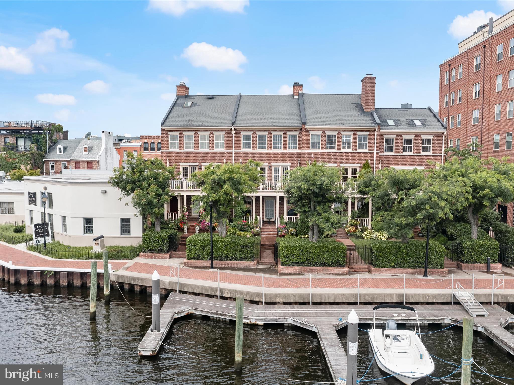 Experience the pinnacle of waterfront living in the heart of historic Fells Point with this exquisite townhome showcasing sweeping views of the Inner Harbor. Thoughtfully designed with timeless elegance and modern convenience, this exceptional residence includes a private dock with a deeded boat slip, offering a rare and coveted opportunity for effortless access to the water. Enter through the charming waterside front door or via the attached garage into a welcoming entry-level family room or third bedroom adorned with rich hardwood floors, plantation shutters, crown molding, and recessed lighting. A stone-tiled foyer, convenient full bathroom, and ample storage combine beauty with practicality. A private elevator gracefully serves all three levels, enhancing the ease of daily living. The main level captures mesmerizing harbor views from nearly every vantage point, including the chef’s kitchen, appointed with 42” cabinetry (some with glass-front displays), granite countertops, a center island, decorative tile backsplash, stainless steel appliances, wall and convection ovens, and a wine refrigerator. The kitchen flows seamlessly into the formal dining room and an expansive, light-filled living room with a wood-burning fireplace, and direct access to one of two generous balconies, perfect for al fresco entertaining or quiet waterfront mornings. Upstairs, the primary suite is a tranquil retreat featuring a walk-in closet, private laundry, and a spa-inspired en-suite bath with a skylight, heated flooring, dual heated towel racks, and a custom ceramic tile walk-in shower. An additional bedroom with stunning water views and a full hall bath completes the upper level with equal parts comfort and sophistication. Enjoy an unmatched lifestyle just steps from the vibrant shops, renowned restaurants, and cultural charm of Fells Point. With a private boat slip, a waterfront balcony and porch, off-street parking for two cars, and proximity to major commuter routes including I-695, I-395, I-83, and I-95, this coveted offering delivers a seamless blend of luxury, leisure, and location.