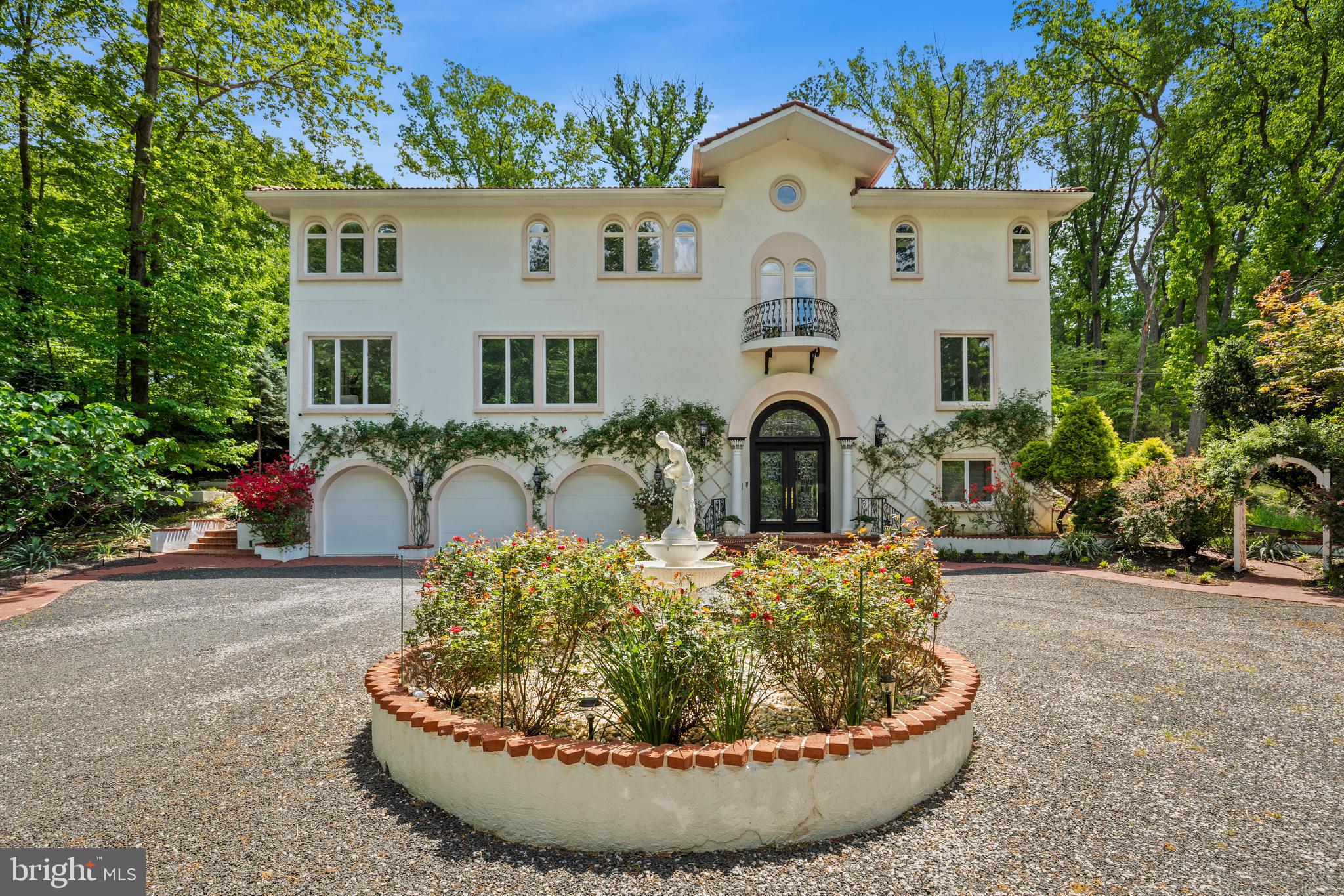 Welcome to this breathtaking Mediterranean-style estate on a beautifully manicured one-acre property in coveted Alexandria, Virginia. Perched on an elevated knoll, down a private driveway, this stunning residence offers majestic elegance in a space that inspires vibrant gatherings, from cocktail parties by the pool to formal entertainment in the opulent dining room. The architectural details and finishes evoke timeless European charm, from the stucco exterior and terracotta roofing to the arched doorways and Palladian windows that bring brilliant natural light throughout the home. Step inside to discover a grand entry foyer with a deliberate receiving area that begs anticipation for what's to come. As you land on the main level, the home takes your breath away with its soaring volumes. Then, step down into the living room, flanked by double doors that open to the pool deck, transporting you to a Mediterranean vacation from your home. The space was carefully designed to accommodate up to eight bedrooms, five of which are en-suites, and home office opportunities ahead of their time. Two bedrooms are on the main floor, including a private suite with direct access to the pool deck. The primary suite commands one wing of the upper level, in the treetops with beautiful open sky exposures. Outdoors, you’ll find gorgeous, professionally landscaped grounds designed for maximum beauty and privacy. A true showstopper, the in-ground pool is the centerpiece of the backyard, surrounded by lush gardens, your private retreat. There is a massive three-car garage, led by the circular driveway, to accommodate significant events. The setting feels like a world away, yet it is just minutes from Old Town Alexandria and the heart of Washington D.C. This home offers an unmatched lifestyle opportunity within a wonderful community.