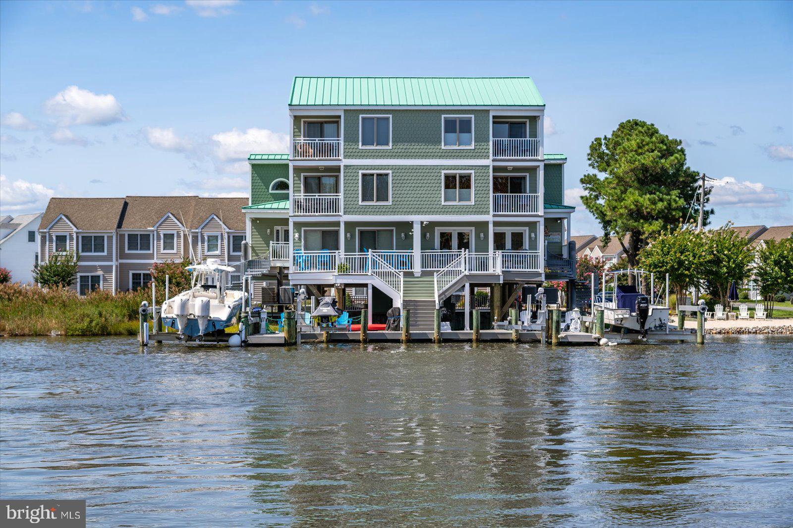 Wow...this is such a unique property you have to see if to believe it ! Did I mention the rare private sand beach deeded as a separate lot & is zoned as a buildable lot ideal for relaxing or entertaining. Located in North OC on the well known and popular Madison Ave. Experience coastal elegance in this stunning 4 bedroom-4 1/2 bath waterfront retreat. Spanning 3 levels, this beautifully designed home offers breathtaking bay views from every floor, with private balconies on each level . The kitchen has top of the line stainless appliances (Wolf and Sub Zero), granite counters, new tile backsplash, stunning cabinetry, eat in bar, wine fridge, wet bar and ice machine for those avid boaters. The 2 owner suites are finished with private balconies and bathrooms, 2 guest bedrooms also with private bathrooms. Enjoy direct access to the water with your own private boat slip, boat lift (16,000 lb) and jet ski lift, perfect for boating enthusiasts. Levels of trek decking to finish off the outdoor living spaces. This townhome/semi detached has NO HOA fees, No City taxes. Open house Saturday, May 24, 10:00-1:00