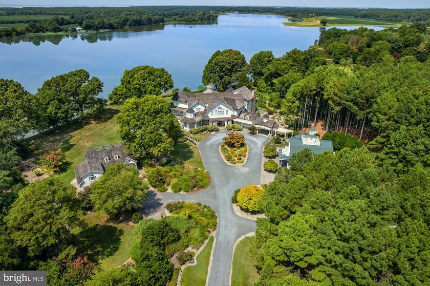 NEW PRICE! Located minutes from downtown St. Michaels, “Aqua Vitae” the waters of life, sits on 8.6 private acres on Harris Creek, a Chesapeake Bay tributary. This custom-built offering w/ over 400’ of direct water frontage is comprised of 3 magnificent structures: a grand main residence, guest cottage, & “party barn” all highlighted by a waterside pool, pier w/ 4’ MLW, pine grove, putting green, extensive landscaping & incomparable craftmanship. The 12,000 SF main residence, positioned to prioritize water views, welcomes you via prominent double lead-glass doors & a grand 3-story foyer w/ dual-staircase. The “river room” w/ 2-story octagon copula offers 270◦ views of the property & creek. The TV room w/ 3 exposures & gas-burning fireplace offers double French doors on two sides leading to the wrap-around flagstone patio. The stunning gourmet kitchen is a true chefs dream.  Offering oversized island, built-in media/storage cabinet, coffered ceiling, fireplace, 3 sinks, double Subzero fridges w/ freezer drawers, 2 beverage drawers, 3 dishwashers, Wolf microwave & a stainless-steel Lacanche range with 6-burners, pot warmer, warming oven, & 2 ovens.  Complimenting the kitchen is a large walk-in pantry w/ dishwasher, sink & extra freezer in hall.  Off the kitchen is a covered porch w/ gas fireplace & “ghost’ screens, a perfect spot to enjoy evenings. A large open dining room has 2 custom built-in display cases. The grand salon w/ bay window, gas-fireplace & intricate mantel is reminiscent of Paris.  Adjoining the salon is the handsome 2-story curly cherrywood library w/ custom display cases & leaded-glass pocket doors. The adjoining climate-controlled wine room has a wet bar & storage for 750+ bottles.  Wood floors flow throughout the entire main level. The main level is completed by an office, powder room & laundry to service the pool, 2 additional powder rooms, elevator to all 4 levels, mud/dog room, rear spiral staircase, guest suite w/ ensuite bathroom, & 2-car attached garage. The 2nd level offers a generous primary suite w/ fireplace & full length terrace overlooking the water. Her wing features dressing room w/ custom built-ins, separate sitting room, & a luxurious bathroom w/ marble tile, separate shower, jetted tub, & vanity. His wing offers an office w/ fireplace, paneled closet leading to separate bathroom w/ shower, travertine stone, & vanity. From his office access the 2nd level of library, open to below.  Just off of the primary suite is a bar area/kitchen. 3 additional bedrooms, each w/ ensuite bathroom, and a laundry room complete the 2nd level. The 3rd level offers theater/rec room, play area, bedroom w/ ensuite bathroom, powder room, & ample storage. The lower-level houses utilities, storage, & enough room for an exercise area.  The charming guest cottage sits  amongst extensive landscaping. The main level offers a full kitchen, dining area, living room, sunroom, large family room, 2 bedrooms w/ shared bathroom, additional guest bathroom, & large entertaining room.  Upstairs is a full bedroom w/ ensuite bathroom. The unfinished lower level offers storage. The party barn originally built for boat storage was designed to look like an old Pennsylvania barn w/ 4’ of stone around the base. Flanked by 2 garage wings allowing for 4+ cars & capped w/ a cupola, the shingled-style barn has two large doors on either side of the building that allow for a trailered boat or 4+ more cars.  The 2nd level is a loft w/ sleeping/living area w/ full bathroom, plumbed for potential kitchenette, front & rear terraces, & a spiral staircase to a crow’s nest  w/ amazing views. There is a full property generator & a dog run w/ kennel just off the rear.  Outside enjoy the benefits of beautiful shore living amongst the verdant grounds, mature landscaping & exceptional views. The pier offers 4’ MLW & the shoreline is fully rip-rapped w/ natural plantings.