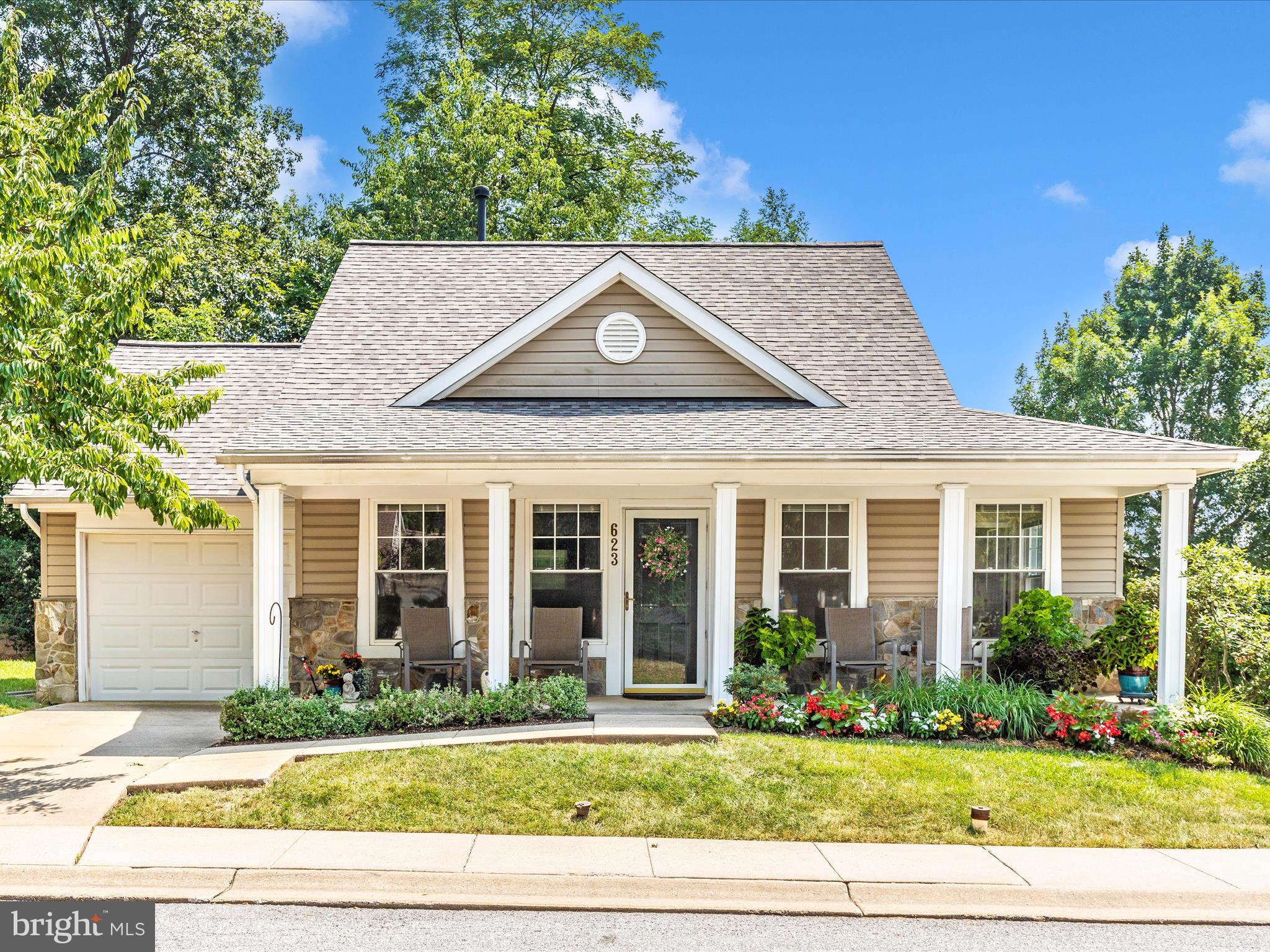 A perfect 10 in the highly desirable 62+ community of Wildwood Park. This unit features single level living with all of the space you need, and none that you don't. The outside curb appeal of this home is stunning. Corner unit with a fabulous front porch perfect for relaxing and greeting your neighbors. Parking in your single car, attached garage, or driveway. Enter the home and find a wonderful wide open floorplan. The living/dining room offers a beautiful front window and is a blank slate for you to arrange your furniture to suit your needs. Flow into the sunny kitchen with ample storage and counter space. Updated kitchen appliances, a door to the back yard and garage, and table space round out this fully functional kitchen. Bedroom 1 offers a walk-in closet and an attached full bath. The primary bath features a walk-in shower and sink vanity. Bedroom 2 is similar in size and has a hall full bath to accompany it. A hall linen closet offers storage for both bathrooms. The garage has pull down stairs for attic access. Finally, the rear yard is just lovely, with full privacy from a row of mature evergreens, creating a screen from the rest of the world. The owners have meticulously taken care of this hone with a new roof in 2025, new lighting, new appliances, new faucets, and new WI-FI thermostat. All systems have been serviced regularly. All of this, just a stones throw from the Mount Airy Senior and Community Center, the Library, dog park, multiple grocery stores, and tons of shopping and restaurants.