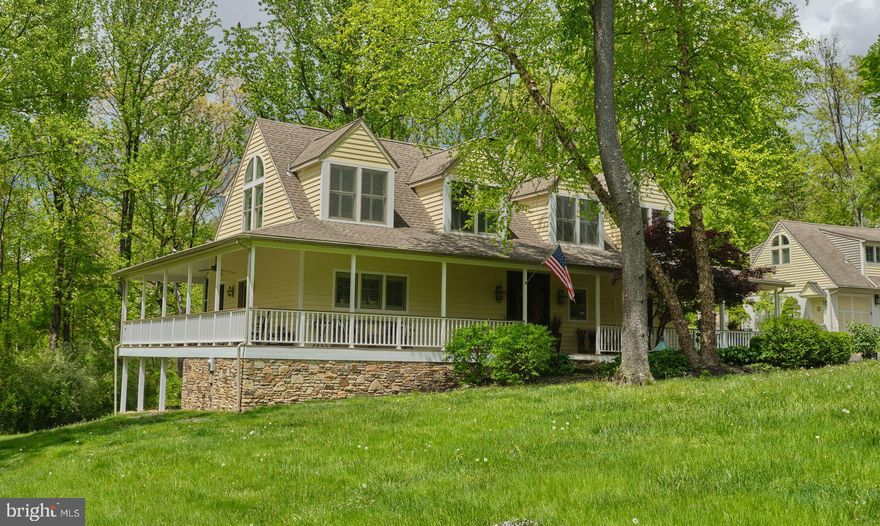 Nestled on a private 1.3 acre lot, this meticulously custom-crafted Southern Cape has an expansive wraparound porch with breathtaking views in every direction. Exquisite details abound both inside and out. Wide plank hardwood floors, large windows with plantation shutters, custom built-ins and detailed moldings grace the home's spacious rooms. A welcoming entry leads into an open living & dining room  with a wood burning fireplace, perfect for entertaining or enjoying quiet evenings at home. The gourmet kitchen features a convivial center island, soapstone counters, stainless steel appliances, custom cabinetry, and built-in wine bar. French doors lead from the dining room to a screened in porch and deck overlooking the rolling lawns with mature trees and a babbling stream. A stunning first floor Owner's Suite has a lovely fireplace, French doors opening onto the deck, and handsome bath with seamless glass shower. A convenient laundry and powder room complete the first level. Upstairs, A second en-suite bedroom with vaulted ceiling has a private bath and balcony with peaceful views. two other large bedrooms share a hallway bath.  Downstairs find a tall walk-out unfinished basement with top grade utilities.  A detached oversized two-car garage in the same Southern Cape style has a spacious finely finished studio space above. Enjoy your own lush paradise with extensive Jerry Fritz landscaping and hardscaping enhanced by uplighting and watering system. A tranquil pond complete with two resident swans and walking trails are shared with four neighboring custom homes.  this lovely New Hope home provides country living at its finest. The property is located 10 minutes to New Hope, 37 minutes to Princeton, and under 90 minutes to NYC.