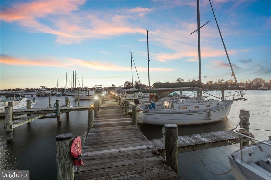 Introducing this extraordinary five-bedroom, four-bathroom waterfront home in Wilson’s Point, set on a magnificent 0.85-acre lot with sweeping views, exceptional outdoor amenities and approximately 165-feet of water frontage. This property delivers a true waterfront lifestyle and a rare income-producing opportunity with a private pier featuring 28 slips, each equipped with power and water. With three levels of living space inside, the home blends modern updates with classic charm throughout. Elegant crown moldings, glass French doors, and abundant natural light shape the inviting main level. The living room is anchored by a stacked-stone fireplace with a wood stove, complemented by a recently installed mini-split system for added comfort. Prepare your favorite meals in the updated kitchen that boasts granite countertops, a tile backsplash, 42” cabinetry, a center island, and stainless steel appliances. The adjacent dining room offers a warm space for hosting gatherings with a pellet stove. A four-season sunroom provides stunning waterfront views, a second pellet stove, a full bathroom, and access outside. The main level also includes a laundry room and a foyer that opens to a screened-in porch. Upstairs, the redesigned primary bedroom is a tranquil retreat with beautiful water views, two walk-in closets, and an updated ensuite bathroom with a dual-showerhead walk-in shower. Two additional bedrooms with walk-in closets share an updated hall bathroom with a frameless glass walk-in shower. A versatile two-story den offers flexible use as an office, sitting room, or exercise space, leading to the top level with a loft and two more bedrooms. Outdoor living is unmatched, with a side deck and covered porch for enjoying sunsets, a lush lawn for recreation, and an expansive screened porch at the back of the home for relaxing or entertaining. An outdoor bathroom with a walk-in shower is ideal for guests coming in from the water. The detached two-level garage accommodates three vehicles and includes a workshop and attic storage, while a fenced patio beside the garage provides another outdoor gathering space. Ample driveway parking for at least ten vehicles completes the setting. Nestled in Wilson’s Point, this home offers the perfect blend of a quiet waterfront community and convenient access to major routes, restaurants, marinas, and all that Middle River has to offer.