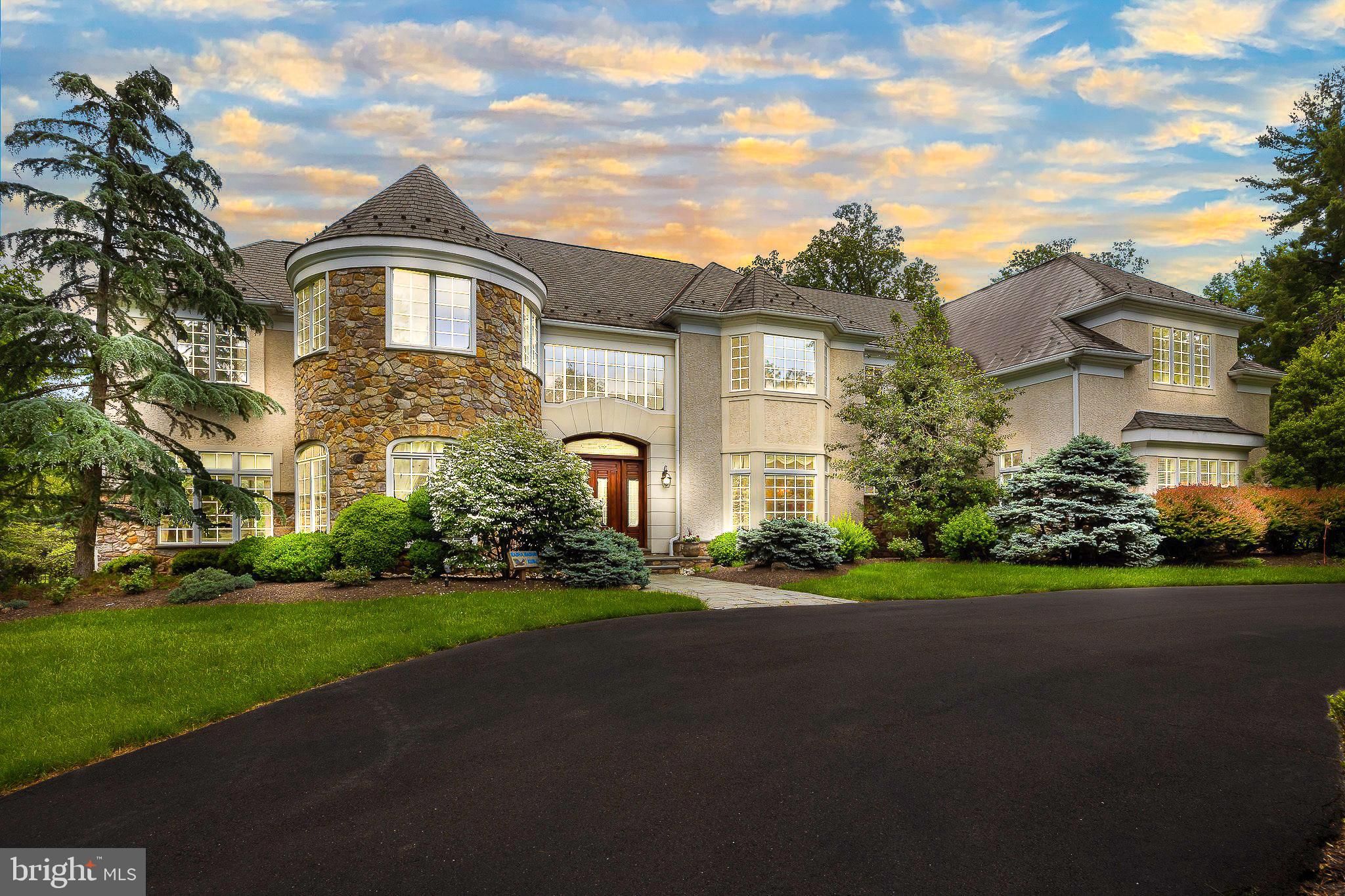 Welcome to 1049 McKean Road, the crowning jewel of Horsham Twp - where timeless elegance meets modern luxury in this extraordinary custom-built estate nestled on 14.62 whimsical, park-like acres - only 2 acres are grassy and require maintenance, with the remainder being wooded. A long private drive and charming wooden bridge set the tone for the serene lifestyle that awaits. Framed by meticulously manicured landscaping, this nearly 12,000 sq. ft. Manor Home offers 5/6 expansive bedrooms—each with its own Full Bath and Walk-In Closet—designed for both grand entertaining & private comfort. Upon arrival, the circular driveway invites you into a breathtaking Two-Story Foyer adorned with limestone flooring, a striking turned oak staircase with carpet runner, and a sparkling hanging crystal chandelier, all beneath a second-floor Balcony. To the left, the turret-style Living Room enchants with oversized windows, luxe carpeting, and recessed lighting, while the Formal Dining Room on the right impresses with hardwood floors, another dazzling chandelier, and elegant trim work. The gourmet Kitchen is a culinary dream, outfitted w/ rich cherry cabinetry, granite countertops, GE Monogram stainless steel appliances, a center island with seating for six, and a Walk-In Butler’s Pantry—all connected to a vaulted Great Room featuring 27’ ceilings, a custom mahogany entertainment center, floor-to-ceiling stone fireplace, surround sound, and a second oak staircase to the upper level. Additional main-level highlights include a richly appointed Home Office and a light-filled Conservatory w/ a gas fireplace and stunning quarter-sawn oak hardwood floors accented with a walnut medallion inlay. Upstairs, the turret-style Primary Bedroom Suite is a luxurious private retreat. Vaulted ceilings are adorned with exquisite hand-painted artwork, extending into the cozy Sitting Room w/ its own gas fireplace. Dual Walk-In Closets provide abundant storage, while the lavish Primary Bath features marble floors, dual vanities, walk-in shower stall, and his-and-her water closets, and a deep jacuzzi tub—every element designed for indulgent relaxation. A spacious upper-level Laundry Room includes two washers, two dryers, a utility sink, and a separate space for folding, hanging, and ironing. The uppermost level offers a Finished Loft/Recreation Room with tranquil views of the Backyard Oasis. The fully finished Walk-Out Basement provides an additional layer of luxury and comfort, featuring a large Recreation Room, Guest Bedroom, Exercise Room, Full Bath with steam and walk-in shower, and a dedicated Theater Room. Two separate staircases ensure seamless access to the Main Level, while recessed LED lighting enhances the ambiance throughout. Step outside to your own private resort: a fenced Backyard Oasis complete with a resurfaced custom concrete Patio, In-Ground Pool with updated tiles, coping, and a motorized retractable cover, a rejuvenating Spa, and a Pool Shed. Nearby, a refinished Koi Pond with flagstone Seating Area invites moments of serenity, while professionally installed paver walkways connect the home’s front and side entrances. Additional features include a 7-zone high-efficiency HVAC system powered by a condensing natural gas boiler & furnace for year-round comfort, an Attached Heated 3-car Garage with epoxy floors, storage closets, and guest-accessible Powder Room, plus a Detached 3-car Garage with updated roof, concrete flooring, and separate electric service. A whole-home natural gas Generac generator, irrigation system, exterior LED accent lighting, 400-amp electrical service, newer water heater, and fresh interior paint and carpeting throughout further enhance the value and sophistication of this remarkable estate. Experience unparalleled privacy, craftsmanship, and luxury living at 1049 McKean Road—an extraordinary retreat that truly has it all. Nowhere else will you find a home of this size on this many acres in Horsham Township!