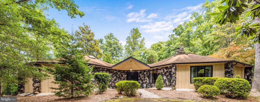 Seller says sell!  Nestled within a private enclave of four residences, this extraordinary contemporary home offers unparalleled privacy, a prime location, and main-level living. Situated on two acres of landscaped grounds with meandering paths, lush foliage, and a luxurious pool oasis with an outdoor cabana, this property exudes exclusivity. The exterior design features striking lava rock accents that lead to vaulted ceilings, expansive walls of glass, and elegant pegged oak hardwood floors. The home comprises two conjoined nonagon structures, providing two distinct wings of living space. The first wing boasts an expansive family room with a breathtaking floor-to-ceiling Tennessee river stone fireplace and a chef’s kitchen with soaring 16’ ceilings. The second wing houses four bedrooms and three of four baths. The primary bedroom offers direct access to the pool area and scenic views of the lush gardens and mature trees. This secluded retreat offers the convenience of nearby shopping, dining, and commuting options just minutes away. Embrace the grandeur of this private oasis or unleash your creativity by designing and constructing your dream home.  Visualize the possibilities of what potential future construction could look like on this property within the renderings provided by Benchmark Builders & Developers.