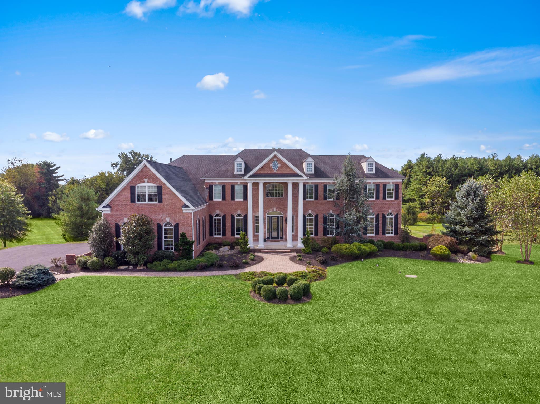 You will instantly fall in love with this Georgian style estate home which is truly exquisite inside and out! Enter through an elegant, open foyer with a gorgeous wrought iron butterfly staircase that invites you into this remarkable open floor plan. Off the foyer is the Dining Room and a Formal Living Room with double crown molding and millwork, Brazilian hardwood flooring and a double sided gas fireplace that leads into a sun-drenched Conservatory. The expanded Study makes a lovely home office and also features a double sided fireplace to the Great Room. The 2-story Great Room will leave you impressed by all the natural light that fills the entire first floor by the wall of windows as well as a spectacular custom built-in wall feature surrounding the fireplace. The brand new Gourmet Kitchen has a large center island, Wolfe and Sub Zero professional appliances, furniture grade cabinetry, walk-in pantry, Butlers Pantry and custom wet bar with tumbled marble backsplash and granite counters. The large Breakfast Room opens to the Naples Room with gas fireplace offering plenty of room to entertain friends and family. A secondary staircase provides access to the kitchen, family room and second level with 5 bedrooms. Your private getaway will surely be in the Master Suite. It includes a spacious sitting area, tray ceiling and recessed lighting and shares a double sided gas fireplace to a relaxing Master Bath. The spa-like bathroom includes double sinks, soaking Jacuzzi, travertine tile floors and seamless shower. It also boasts a bonus room that could also double as a dream closet. There are 2 other generously sized bedrooms which have en-suite baths and the other 2 feature a Jack and Jill bathroom. This level also includes a convenient 2nd floor Laundry. The walk-out lower level is bright and open and has already been roughed out with framing and plumbing which can easily be finished into a wonderful additional space. This impeccable custom built home has been professionally landscaped, has a 4 car garage and is conveniently located to NYC, Philadelphia and Princeton.