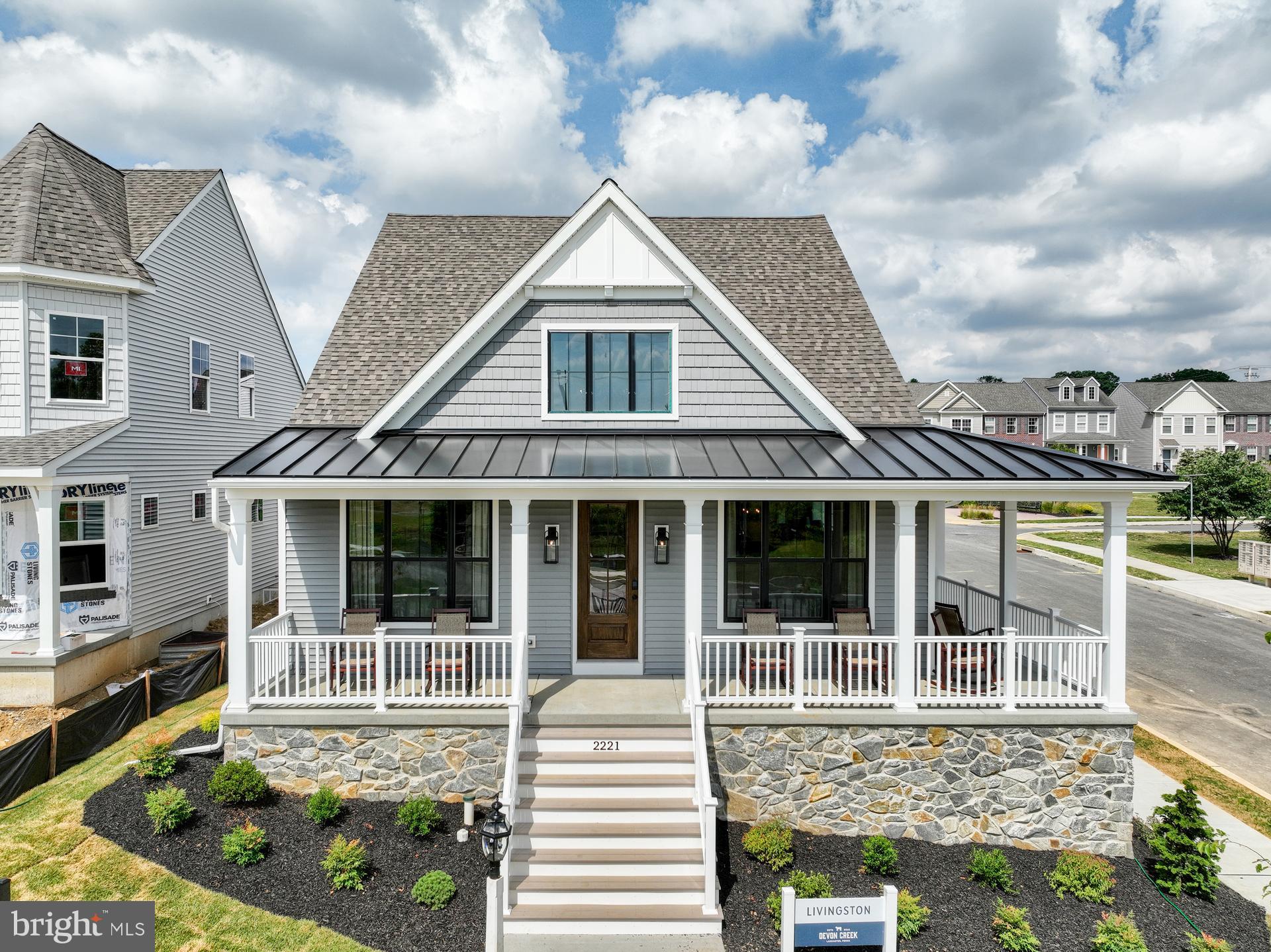 Welcome to the Livingston Manor at Devon Creek, located in Lancaster, PA. This beautiful model home offers three bedrooms, two full baths, along with a half bath. The exterior of this home features a covered, wrap-around front porch and is part of our cottage home style offered at Devon Creek.
Upon entering through the front door you are greeted by a staircase that separates the entry to the Owner's Suite on your left, and the two-story Family Room on your right. Featuring a vaulted ceiling and a Kennedy Gas Fireplace, the Family Room flows directly into the Dining Room and Garden Kitchen. This Kitchen showcases two-toned, wall-to-ceiling cabinets and Quartz Calacatta as the countertop and backsplash. This kitchen also features large cove molding and two Era Black Pendants hanging above the island. Directly off the kitchen is access to the rear covered porch, rear two-car garage, and entry area. The entry area flows into the Laundry Room with vertical shiplap, which conveniently connects to the oversized Owner's Suite walk-in closet and through to the Serenity Bath. This bath features black hexagon tile flooring and a walk-in shower with floor-to-ceiling Savior tile that continues as the backsplash for the split vanity. Opening into the magnificent Owner's suite, this room features a cathedral ceiling, vertical floor-to-ceiling trim, and a large chandelier.
Ascending the stairs reveals a loft space that overlooks the first floor, along with two spacious bedrooms and a Family Bath.
The Livingston Manor is versatile for a variety of lifestyles and needs.
Descending two flights of stairs will lead you to the basement with an impressive additional entertainment space. This space features vertical floor-to-ceiling shiplap and a charming bar cafe.
Discover the ultimate in high-end living at Devon Creek, a new community of homes built by Keystone Custom Homes in Lancaster, PA. Immerse yourself in a warm and inviting neighborhood that offers front porch living, tree-lined streets, and a variety of stunning home styles. Devon Creek Cottages feature five single-family homes with rear-load garages accessed from charming alleys in the community.