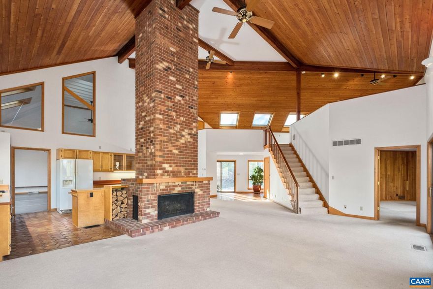 Welcome to Woodhaven: an architectural sanctuary on 6.47 private acres in the Blue Ridge foothills. A rare find offering seamless silence just 5 minutes from Route 29 and 30 minutes from Charlottesville. This atypical, seven-sided Mid-Century Modern masterpiece unfolds around dramatic two- story soaring wood ceilings. A custom oversized fireplace and brick chimney anchor the living spaces, while a sun-drenched loft with solar skylights animates the home. Hand-cut floors and imported terra cotta with floor heat provide organic calm, complemented by a handcrafted cherry-paneled library with built-in bookcases and a two-story professional studio?a light-filled, adaptable creative annex. Extensive investment updates: silent Trane 5-ton HVAC, handcrafted Norwegian pine deck, floating porch, and loft patio. With refreshed baths, full exterior stain, and roof upgrades, the home preserves its soul while enhancing modern performance. This ?sculpture you can live in? creates an unparalleled retreat in a rare permanent quiet zone. Whether seeking a high-performance studio or secluded sanctuary, Woodhaven blends natural inspiration with logistical convenience near airport and Amtrak. Experience where nature, design, and silence unite.,Formica Counter,Wood Cabinets,Fireplace in Great Room