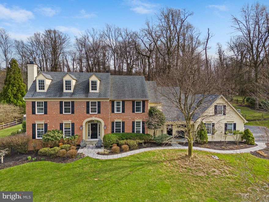 Welcome to 28 Great Woods Lane! This elegant home is situated on over 2 acres in the lovely, well-established neighborhood of Whitehorse in award-winning Great Valley School District. As you make your way up the hardscape walkway, you’ll notice the stately brick front & wood siding – no stucco! From the foyer the warm hardwood floors extend throughout the first floor. On your left is the formal living room with a gas fireplace & crown molding & on your right is the dining room with crown molding & wainscoting. Continue through the dining room into the beautifully renovated eat-in kitchen with 42” cabinets, stainless steel appliances including a Thermador gas range, white farm sink, subway tile backsplash & black soapstone countertops. The island offers room for 3 stools for casual dining plus contrasting white marble countertops & pendant lighting. To access the fenced backyard, make your way through the French doors & step down to the paver patio with a firepit & café lights. The kitchen is open to the spacious family room with a gas fireplace with brick surround & windows overlooking the impressive pool, hot tub & pool house. Off of the kitchen, the mudroom has a brick farmhouse floor, custom cubbies for storage, stackable washer & dryer, the second half bathroom with a pocket door & access to the three-car garage. The remainder of the first floor offers a stately private office with plantation shutters & a view of the pool plus access to one of two half bathrooms. Heading upstairs, you’re greeted by the primary bedroom with a sitting room, tray ceiling & a gas fireplace. There are two walk-in closets each with custom organizer systems. The en suite bathroom has been renovated to include two oversized vanities with marble countertops, extensive custom cabinetry, plantation shutters, free-standing soaking tub, step-in shower with subway tile surround, octagonal Carrera marble tile floor & a glass enclosure. The remaining three bedrooms on the second floor are spacious & bright with generous closet space. They share the updated hall bathroom with a marble topped double vanity with custom cabinetry for storage plus a tub/shower with subway tile surround. If you’re in need of a fifth bedroom for out-of-town guests, make your way down to the finished basement. There is plenty of space for enjoying a sports game or movie, a home workout or crafting. The cozy, private fifth bedroom with plenty of closet space has access to the third full bathroom with a single vanity with granite countertops, step-in shower with glass enclosure & ample cabinetry for storage. At the end of the hall you’ll find the back staircase leading down to the kitchen & family room. Last but not least, make sure you take a walk out to the stunning fully fenced backyard to appreciate the thoughtfully crafted outdoor living space. Stepping off the back patio, it’s just a few short steps to the pool deck. Around the pool is a bar top with seating & a built-in beverage refrigerator, plus a built-in, wood burning fireplace for evening bonfires. The real gem is the gorgeous pool house with stone archways overlooking the pool & hot tub & a massive wet bar with leathered marble countertop & refrigerator. The vaulted ceiling is finished with warm wood paneling, recessed lighting & fan. At the rear of the pool house, there is a private changing room & powder room. A few steps up behind the pool house are the horseshoe pits waiting for an afternoon tournament. Additionally, for efficiency & peace of mind, there are two updated HVAC systems plus a whole house generator. This home is just minutes to Route 29 with access to the PA Turnpike & Route 202 plus Wegman’s & Target! A short drive beyond that & you are in Malvern Borough to enjoy the local shops & restaurants. If you need public transportation with access to Philadelphia or New York City, both the Malvern & Paoli train stations are within a reasonable distance. Don’t miss this opportunity!