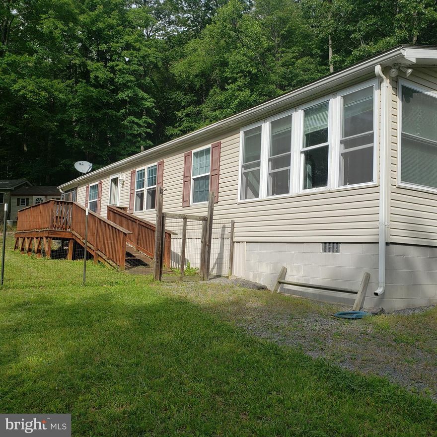 If you are looking for a place to get away,  or a full time residence, and you want a private and peaceful setting you will love living in Grassy  Mountains Woods.   You will feel like you are in the middle of nowhere but less than 10 miles to route 50, and only about 1 miles off paved Grassy Lick Road to the house!  Sought after "unrestricted" property consists of 4 lots wooded and open.  No one living right next door! Lots of wildlife here.  Sit out on your front porch/deck and watch the deer and turkey. Hunt in your own back yard or cross Grassy Lick Road to  the 10K acre Nathaniel Mountain  Wildlife Management area.  This property is a well maintained doublewide with a stick built addition.  There are two nice sheds for plenty of storage.  The propane stove conveys and is a second heat source which can be set to kick in in the event of a power outage to keep things cozy in the chilly weather.  The window filled family room offers lots of natural light for your plants. There is sliding glass doors from the family room to the outside.  Laundry room located off the kitchen with washer and dryer.  And you can enjoy out doors without the bugs on the screened porch.  Must see to appreciate all this property has to offer. Call to schedule your showing today!