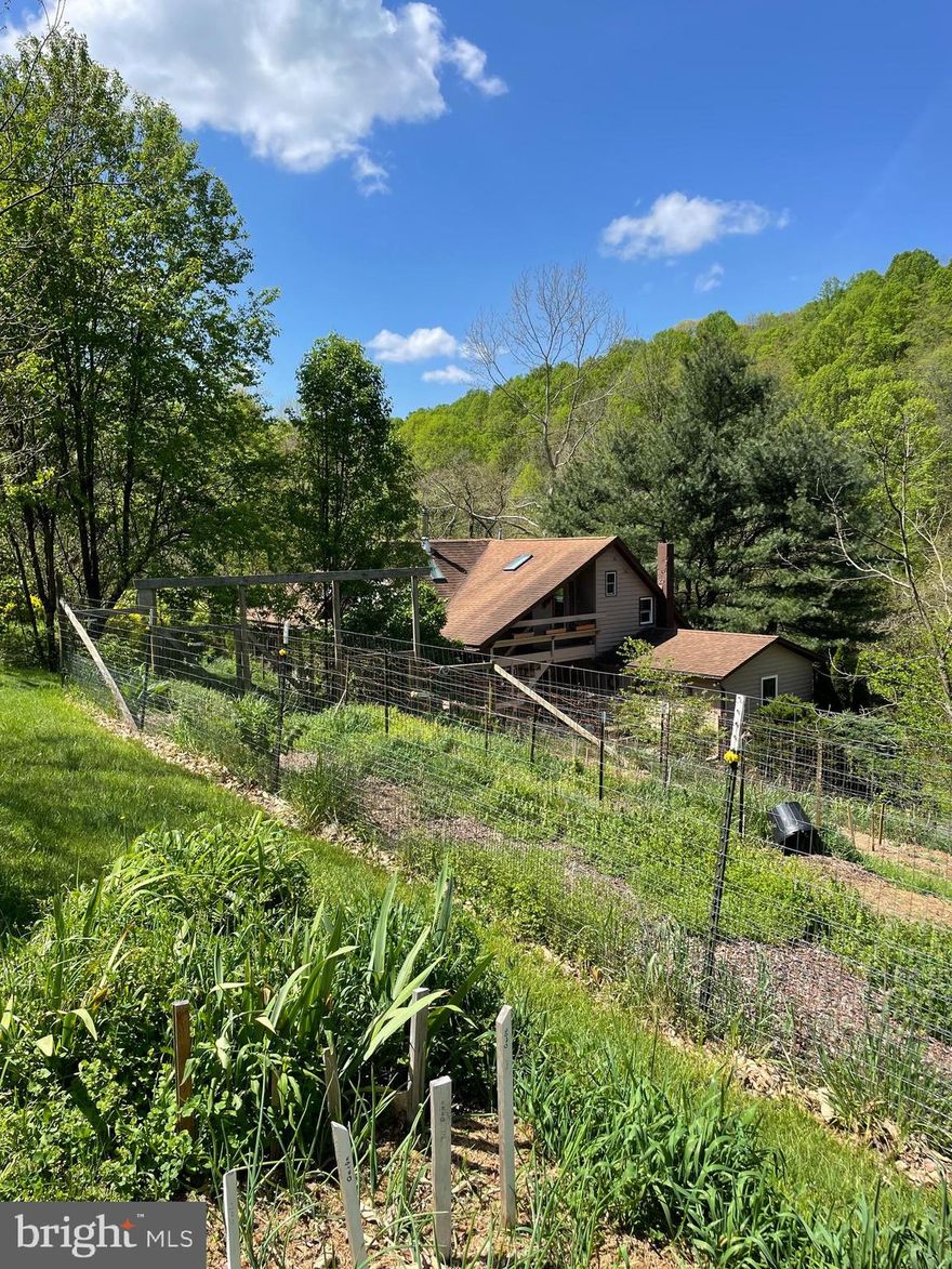 Want your own farm?  Wild Acre Farm is the place for you.  Over 20 years of organic gardening provides you with the best soil.  5 different kinds of nut and fruit trees to add to the bounty.   The 19.69 acres offer lots of wandering space as well as a multitude of flowers to enjoy.  Expand  the gardens and have your own fall harvest. You will love the 2 story post and beam sunroom. The kitchen has new cabinets and countertop. There  is a primary bedroom and bath tucked away from the living area as well as a 2nd bedroom (currently used as an office) and full bath on the first floor.  Upstairs is a 2 bedroom, 1 bath ensuite with exterior entrance for privacy.  More heating choices are provided by a warm pellet stove in the basement as well as a wood stove in the living room area.Don't miss out on this serene getaway.