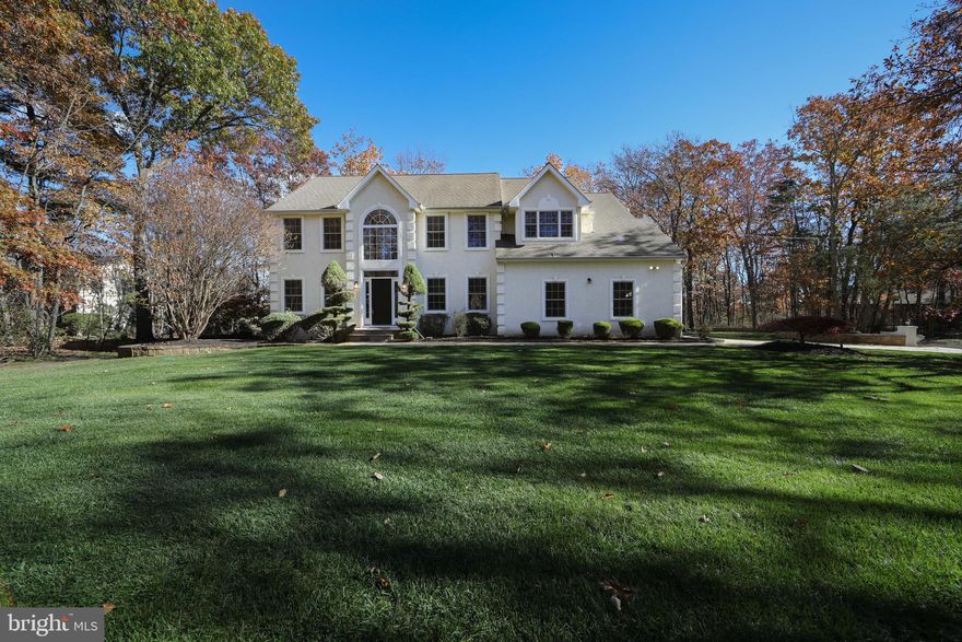 Nestled on a wooded oversized lot, this beautifully maintained Voorhees home offers privacy with convenience. Features include a 2-story foyer, new vinyl plank flooring, crown molding, recessed lighting, and a dramatic 2-story family room with fireplace. The eat-in kitchen boasts stainless appliances, island, walk-in pantry, and sliders to a large deck. Upstairs, the primary suite has a cathedral ceiling, dual walk-in closets, and jetted tub. Updated full bath with dual sinks and custom tiled accent wall. Finished basement with vinyl flooring, cabinetry, and extra laundry. Extensive paver patio, landscape lighting, and side-entry garage complete this exceptional home.