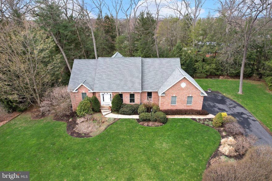 Wonderfully situated on a private, double lot on a cul-de-sac in the Borough of State College, this lovely Randy Bachman built home with a brick front oozes charm and just feels comfortable.  Upon entering the inviting two-story foyer you’ll be greeted by maple hardwood flooring, embellished trim work, and an abundance of natural light beaming through the south-facing windows.  A great place to entertain, the front living room and adjacent dining room feature wood flooring, crown molding & chair rail, a tray ceiling and sconce lighting.  A chef’s delight, you’ll enjoy the spacious kitchen with plentiful cabinetry and countertops, a large island with a gas cooktop and a breakfast bar, a large pantry, plentiful recessed lights, a huge window overlooking the private back yard, a built-in desk area, and a spacious nook area with a newer, large sliding glass door system to take in the views.   Open to the kitchen, feel at home and relax in the large family room complete with a cathedral ceiling, huge windows, built-ins, and a gas fireplace.  A hard-to-come-by first floor primary suite provides ample space, two walk-in closets, and a luxury bath featuring a vaulted ceiling, a heated tile floor, a jetted tub, a tiled walk-in shower, and a dual sink vanity.  The half bath and a large laundry/mudroom with a utility sink and storage cabinets complete the main floor.  Ascend a lovely staircase with maple wood treads to the second floor reading loft area that overlooks the family room and foyer.  Three bedrooms, including a second suite boasting an ensuite bath with a heated tile floor, a walk-in closet, a cedar closet, and a large bonus room, as well as a spacious hall bathroom with a dual sink vanity and a separate toilet and tub/shower area comprise the top floor.  Opportunities abound for future finishing and a potential apartment space in the sprawling unfinished basement with its high ceiling, walk-out, and full bath pre-plumbing.  Enjoy the gorgeous trees, plantings, and private setting from the sizable rear deck or have fun playing in the large grassy yard.  Voted the friendliest cul-de-sac in State College by the neighbors, you’ll appreciate this tucked away spot with no through traffic, wonderful neighbors, and being walking distance to downtown, Penn State’s campus, Lederer Park, Walnut Spring Park and Thompson Woods Preserve.  Come see this lovely home before its gone!