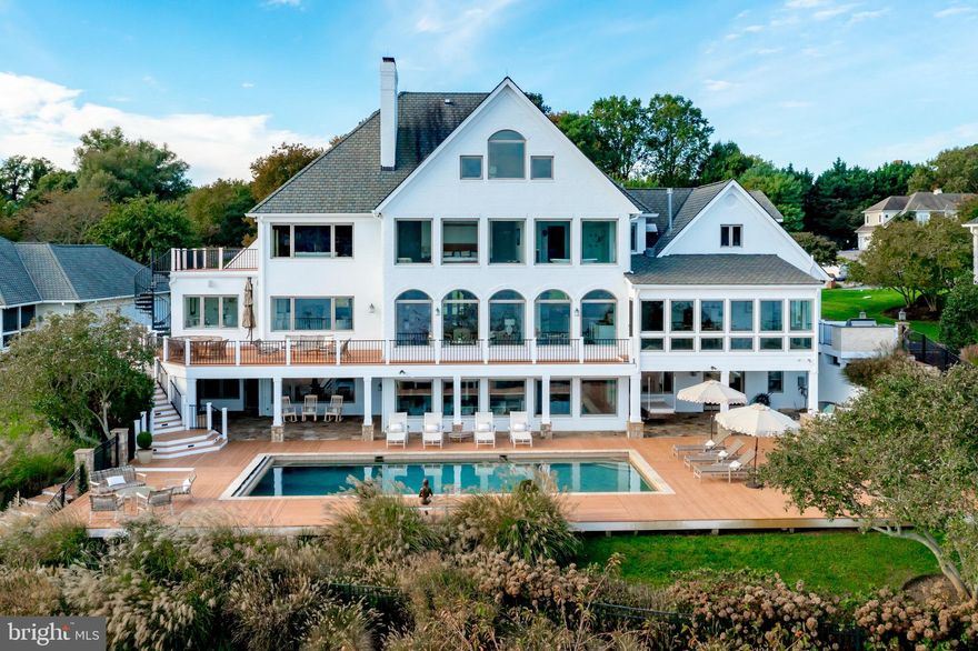 This Severn River Waterfront Estate is a rare and breathtaking Annapolis retreat. Experience the ultimate in waterfront living  in this exquisite  residence,  a true masterpiece offering unparalleled panoramic water views. Nestled on a pristine one-acre site in the prestigious Point of The Downs, this custom-built legacy home has been meticulously updated to perfection, creating the ideal setting for unforgettable family gatherings, holidays, and retreats. Spanning four levels of immaculate living space, this residence boasts designer finishes throughout. The grand chef’s kitchen is a showstopper, featuring elegant white cabinetry, a Sub-Zero refrigerator, a custom bar area, and multiple dining spaces. The luxurious primary suite is a private sanctuary, offering breathtaking water views. Two home offices provide the perfect work-from-home setup, while an elevator ensures seamless access to all levels. Indulge in exceptional amenities designed for both relaxation and entertainment. Six gas fireplaces create warmth and ambiance, while the in-home theater offers the ultimate cinematic experience. A private gym, sauna, and steam room provide a space for wellness and rejuvenation. Outside, the PebbleTec waterside pool, hot tub and outdoor fireplace create a resort-style atmosphere perfect for entertaining or unwinding. For boating enthusiasts, the private deep-water pier features an eight-foot mean low water depth, three slips, and two  lifts with 12,000- and 20,000-pound capacities. A three-car garage with 2 electric charging stations and circular driveway provide ample parking for residents and guests alike. This is more than just a home—it’s a lifestyle. Don’t miss this rare opportunity to own one of Annapolis’ finest waterfront estates on the Severn River.