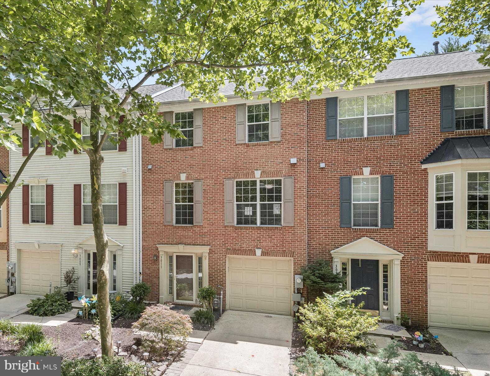 Welcome to this beautiful brick-front garage townhome, offering three beautifully finished levels boasting new flooring and carpet, and fresh interior paint throughout, a new roof, and a fenced backyard creating your own private oasis with an expansive deck and shaded patio, perfect for relaxing or entertaining. Inside, you'll find a bright and airy open floor plan that includes the living and dining areas highlighting hardwood floors and a serene, neutral color palette. The spacious kitchen includes a breakfast nook, a peninsula island, and wood cabinetry. Retire to the primary bedroom suite showcasing a high vaulted ceiling, a large walk-in closet, and an attached luxury bath with a soaking tub, separate shower, and dual vanity. Two additional bedrooms and a hall bathroom complete this level. The lower level provides a storage and laundry room and a walkout family room with a gas fireplace and sliding door access to the shaded patio and backyard. This home seamlessly combines style, comfort, and functionality for modern living. "AS IS" Seller will make no repairs.
