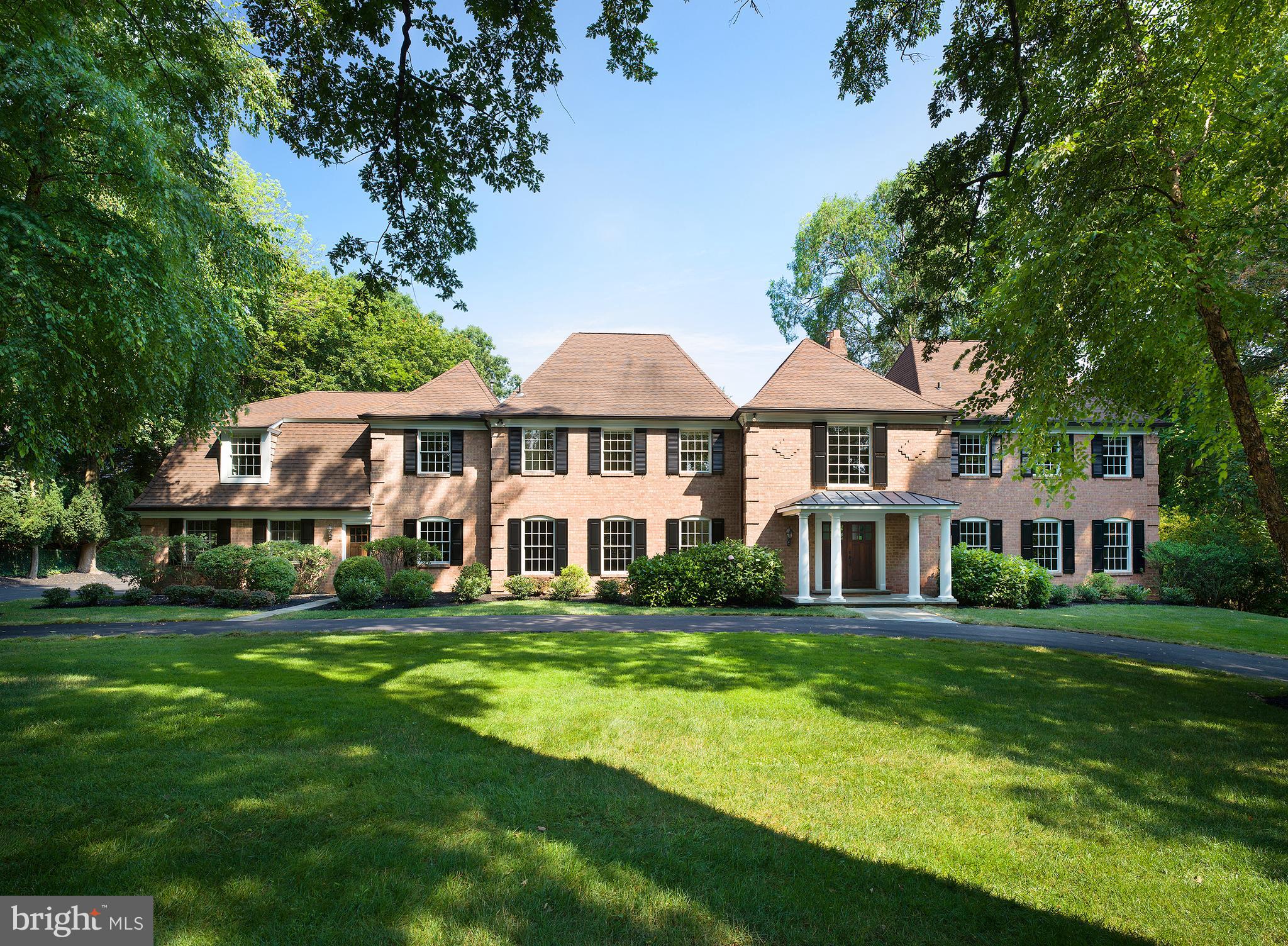 Grays Lane is a home full of versatility: casual yet formal, cozy yet open, modern yet full of character. Here you will find 6 bedrooms, 7 full and 2 half baths, an open floor plan with distinct living spaces, and a large backyard set over 1.14 acres with a spectacular swimming pool and grounds.
This enchanting estate, with functional flow, makes it easy to go from spending time with friends in the formal living room to cozying up with a good book in the library equipped with custom built-ins and a gas fireplace. The attention to detail is evident with rich hardwoods, coffered ceilings, moldings and custom lighting. Enjoy cooking a delicious meal for your friends & family in the light-filled, gourmet kitchen with a six burner Wolf range, Sub-Zero fridge and large pantry. Sip your morning coffee in the sunny adjoining breakfast room. For the afternoon, catch a movie with the family or entertain guests in the spacious family room with double-height ceilings. Here, you can take in the property views, including a beautiful arched Willow tree, through your immense 24-high curved window wall. 2 powder rooms, a convenient mudroom for wet shoes and garage access complete your main level.
Upstairs there is room for everyone to unwind including a grand primary suite with two luxury spa baths, custom-fitted walk-in closet, and a gas fireplace. Plenty of space for the kids, their friends and guests with 5 generous guest bedrooms, 4 fulls baths and a laundry room with storage. In the evenings, head down to the finished lower level, complete with a full bed and bath, to grab some Rioja from the wine cellar and relax by the wet bar, or cozy up next to the fireplace.
If you prefer the outdoors, wander outside and take in the fresh air and beautiful landscape as you stroll through the picturesque, backyard. Several flat lawn areas are perfect for large outdoor gatherings, like a game of tag or football, egg hunts, Halloween hay rides and other family activities. Beyond the beautiful stone wall and iron gate you will find the large, heated pool with a nearby sitting area for you and your family to gather on warm summer days. Incredible storage space, 2 cedar walk-in closets and a resurfaced garage floor add to the appeal of this upgraded Georgian Manor. All this in a convenient location near many amenities and in the award winning Lower Merion school district.