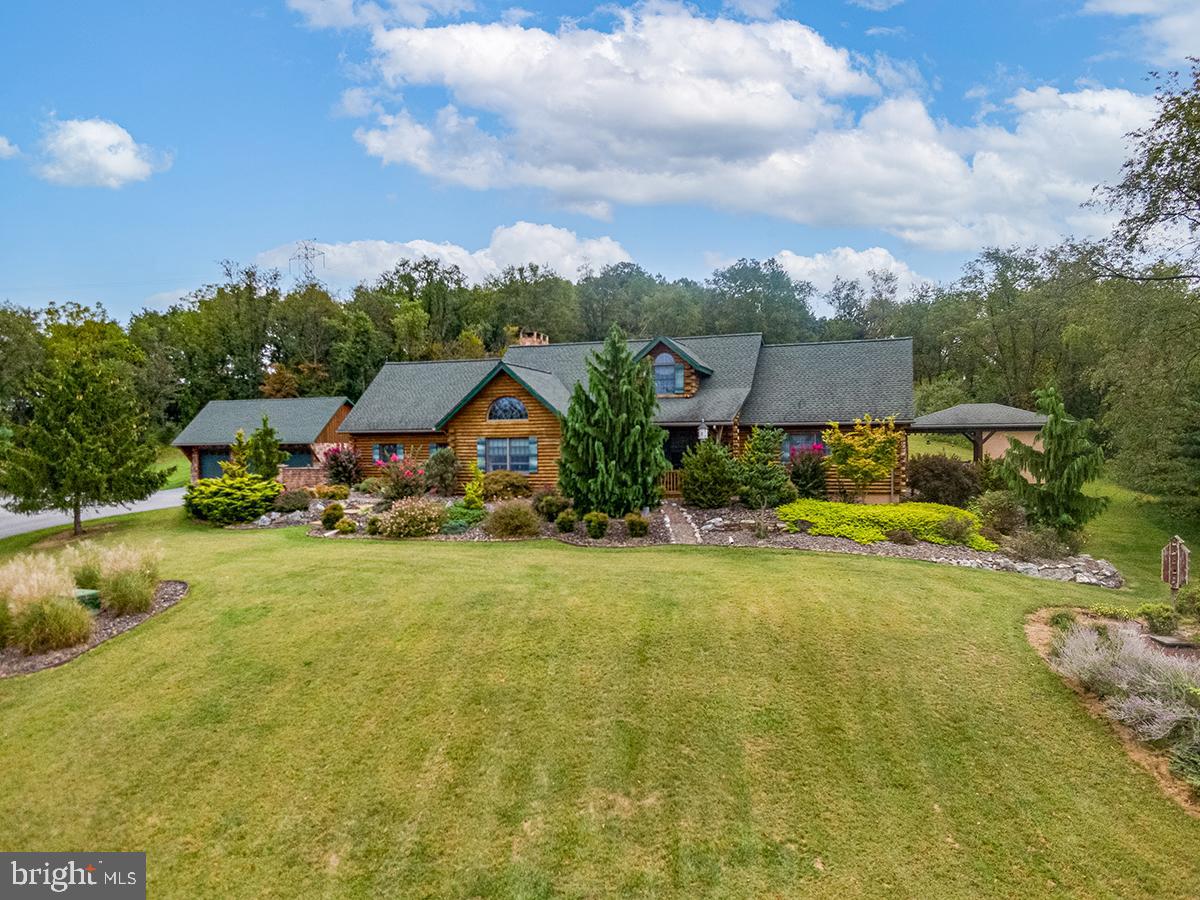 Don’t miss this stunning 3,900± sq. ft. log home nestled on 9.36 acres in the Schuylkill Valley School District. Blending rustic charm of a lodge with modern comforts, this home offers everything you need for both relaxation and entertaining, inside and out. Step inside to find the living room which is open to the second floor adding to the charm. The upgraded kitchen is generously sized, making it ideal for cooking, gathering, and hosting. You will also find the spacious first-floor primary suite with a full bathroom, perfect for convenient single-level living. The patio area in the back has been finished to enjoy the winter days or the hot summer days with the propane grill, large exhaust fan and plenty of seating for burgers. The finished lower level features plenty of room to grow and a custom bar area which is perfect for entertaining, plus an additional unfinished space that would make a perfect workshop or hobby room that is a walkout design . Outside, where do we start! Summer days are meant to be spent at the beautiful inground pool, complete with a pool house for changing and storing equipment, as well as plenty of patio space for lounging and entertaining. Is parking a concern? Enjoy ample parking with a 2-car attached garage and a 3-car detached garage perfect for the car enthusiast or for other toys that you will want at this home. This property combines privacy, function, and luxury in one exceptional package—an opportunity you won’t want to miss.
