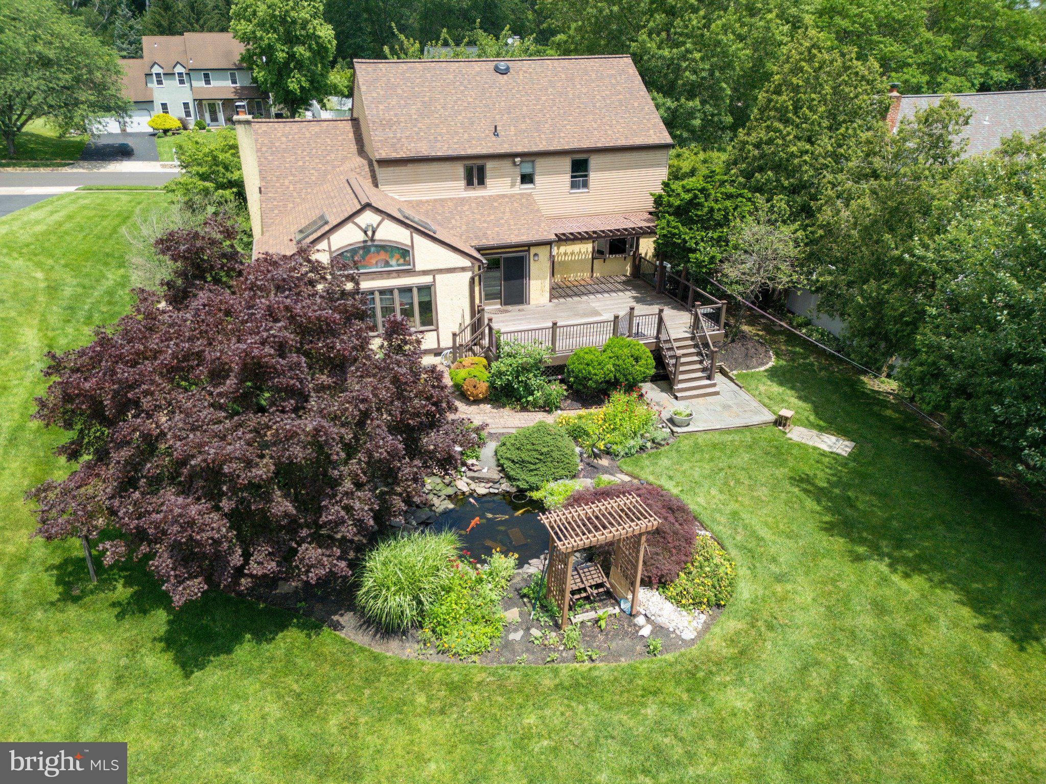 Timeless Tudor Elegance-property in the desirable Nob Hill development on 1/3 of an acre of land and directly across from Tyler State Park. Located in the acclaimed Council Rock School District. Welcome to this exceptional, authentic stone and wood Tudor, a rare gem offering nearly 3,000 square feet of thoughtfully designed living space in the heart of desirable Newtown. Built by renowned builder David J. Schrenk, this character-filled 4-bedroom, 2.5-bath home is set in an established neighborhood with sidewalks and streetlights, just steps from scenic Tyler State Park and the historic Schofield Ford Covered Bridge. Inside, you'll find a sun-drenched family room with skylights, vaulted ceiling and Stained Glass transom windows. There is a working stone wood-burning fireplace with a top-of-the-line high-efficiency insert and a warm, inviting layout perfect for entertaining and everyday living. The spacious eat-in kitchen features a large breakfast island with enough room for a full-length dining table. French doors lead outside to a massive rear deck overlooking a beautifully landscaped backyard, garden beds, and a serene koi pond with waterfall features. The first floor also includes a powder room, foyer and a formal dining room and living room with custom wood ceilings. All with hard wood floors- you’ll find a comfortable flow designed for both work and play. Upstairs, the primary suite is a true retreat with a huge walk-in closet and a luxurious ensuite bath boasting a Jacuzzi tub, walk-in shower, and vanity station. Three additional bedrooms are generously sized with large closets and share a well-appointed full bath. Bonus features include: Two Heat Pumps and 2 A/C units for Dual zoned for added comfort upstairs and downstairs. Back Up Oil Heat. Full basement partitioned for leisure, storage and workspace with a one-of-a-kind “speakeasy” wine room. 2 Door attached garage easily fits 2 cars with plenty of additional space and additional storage in the 2nd attic. 4-car driveway with freshly sealed asphalt Brand new roof and gutter system Located minutes from historic Newtown Borough, this home puts you close to Revolutionary War-era charm, distinctive shopping, and nationally recognized dining. Plus, you're just moments from major north-south roadways for an easy commute. This one-of-a-kind home blends historic charm, modern comfort, and an unbeatable location. Come experience the lifestyle you’ve been waiting for.