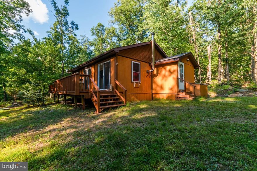 Turn-key cabin situated on beautiful wooded 5 acre lot with private community access to the Cacapon River.  This 2 BR, 1 bath cabin comes fully furnished and has had new roof, flooring, exterior and interior paint within the past year.   Perfect for a weekend getaway or those who wish to downsize.  Fiber optic internet is available.  Don't miss out, call today for your viewing!