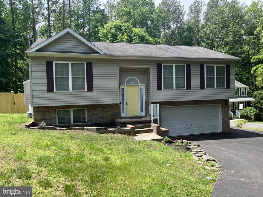 This is a lovely split level home in the Oakland Park neighborhood.  You enter through a foyer with stairs leading to the spacious main floor.   The living room features a fireplace.  The dining room is just off the kitchen, which features a large island,  plenty of cabinets, and a sliding glass door leading to the large deck and backyard.  The home has a full bathroom, two bedrooms and a main suite with its own luxurious bath.  The basement is partially finished with a laundry room and a garage entrance.  The private backyard backs to the watershed.