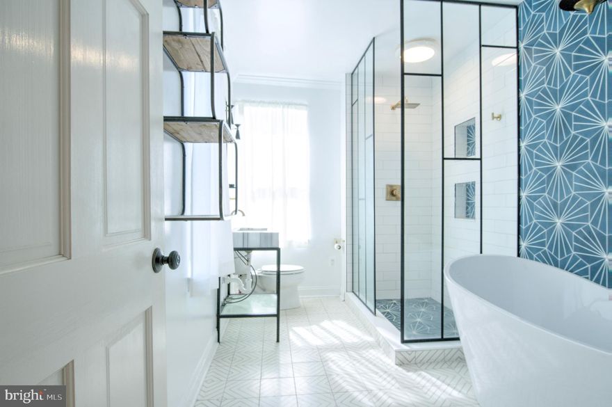 Welcome to 1622 S Charles Street, a spacious Federal Hill residence offering four bedrooms and two full baths across nearly 2,300 square feet of living space. This home blends classic Baltimore charm with modern updates, featuring hardwood flooring, tall ceilings, and a main level that flows seamlessly from living to dining to kitchen. The second level showcases a full bathroom with bold designer finishes, including a glass-enclosed shower, freestanding soaking tub, and striking tilework that create a spa-like retreat. The third level offers two additional bedrooms, with the rear room providing direct access to the brand-new rooftop deck where sweeping city views create the perfect backdrop for summer evenings. The finished lower level enhances versatility with a family room, full bathroom, and a private room that works beautifully as a guest bedroom, and with its separate front entrance, it also presents excellent potential for private living quarters or rental use. A tankless water heater provides energy efficiency and endless hot water, while outdoor living continues with a private rear patio, ideal for gatherings, all just steps from Riverside Park, local shops, and popular restaurants in one of the city’s most sought-after neighborhoods.