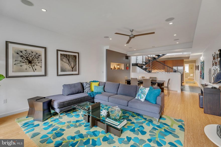 Once a former wharehouse, this unique, custom-built, 18 foot wide space was reimagined into a 3 Bedroom, Den, 2.5 Bath modern residence.  Its oversized, 1 CAR GARAGE door and custom fabricated steel entry pay homage to its previous life while beyond the facade, a truly contemporary home unfolds within. Upon entry, the ground floor opens into an unexpected hall where a curved, polished plaster wall ushers you into the expansive interior, where a dramatic steel floating staircase continues vertically through the entire core of the residence. The sightlines extend from the ground floor all the way to the apex of the structure by a 3 story angled wall where a double pitched SKYLIGHT filters natural light from above, creating a truly impressive sense of scale and illumination. Juxtaposed against the curved wall, a cubed space houses the laundry room and entry to the garage.  Past the central core, a sliding wall reveals the Master Suite; designed for peace and tranquility where one can shut completely off from the city lights and sound.  Sliding glass panel doors reveal a custom, linear ELFA closet system, while a second walk in closet is nearby.  Carved out of the slanted wall, a frosted pane of glass filters light into the Master Bath.  A Wenge stained, custom built double vanity, dual recessed medicine cabinets and a linen closet offers an abundance of storage.  Luminescent shell mosaic tiles accent the generous shower, hosting three Grohe shower fixtures and an elongated niche.  Ascend the gracious staircase where the Living area and Dining area feature high ceilings, floor to ceiling windows which flank a modern tiled wall that hosts a contemporary ribbon flame GAS FIREPLACE.  Past the open atrium, the Kitchen is carved out of the slanted wall to reveal the custom built cabinetry, Jenn Air Stainless appliance suite, White Quartz counters, under cabinet lighting and a subtle art glass backsplash. Behind the Kitchen a full Bath features stacked floor to ceiling tile with a deep soaking tub, niche and European vanity along with a spacious second Bedroom. The Third floor comprises of an open Den and a third Bedroom and half Bath positioned on one side of the staircase while walking over the industrial catwalk you'll take notice of the wet bar and wall of glass that reveals the South oriented roof deck featuring Ipe decking, recessed deck lighting, outdoor audio, and gas line for your grill or fire table, creating a truly impressive outdoor experience. Opening the double glass doors creates an extension of the home while entertaining. Throughout the home, bright white painted walls create a backdrop to showcase your coveted art and sculpture. Other notable features include: 2 zoned HVAC, Ring Doorbell, Master Bath heated floors, In ceiling speakers throughout much of the space and plants and indoor trees thrive from all the natural light!  Walk to the end of the block to experience Carpenter Green, a neighborhood park where you can bring your pooch and meet friendly neighbors. Lincoln Square is just 3 blocks away for local shopping at Sprouts Farmers Market, Petsmart, Target and Wine & Spirits shop.  Easy transit nearby and walkable to local hospitals and Rittenhouse Square. This home has been meticulously cared for and ready for the new owner to fall in love living here!  Listing agent has a financial interest in the property.