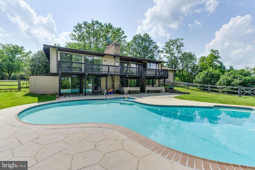 Fabulous deck house with beautiful acreage (2.38 acres) near Sugarloaf Mountain, in Comus, suitable for horses. Custom built, large open floorplan with 12 foot beamed ceilings and walls of windows. Hardwoods, radiant heat tile floors, corian counters, large bedrooms/closets. Deck overlooks heated inground pool with spa. Many upgrades, storage shed, flower beds and fruit trees. Poolesvillle Schools