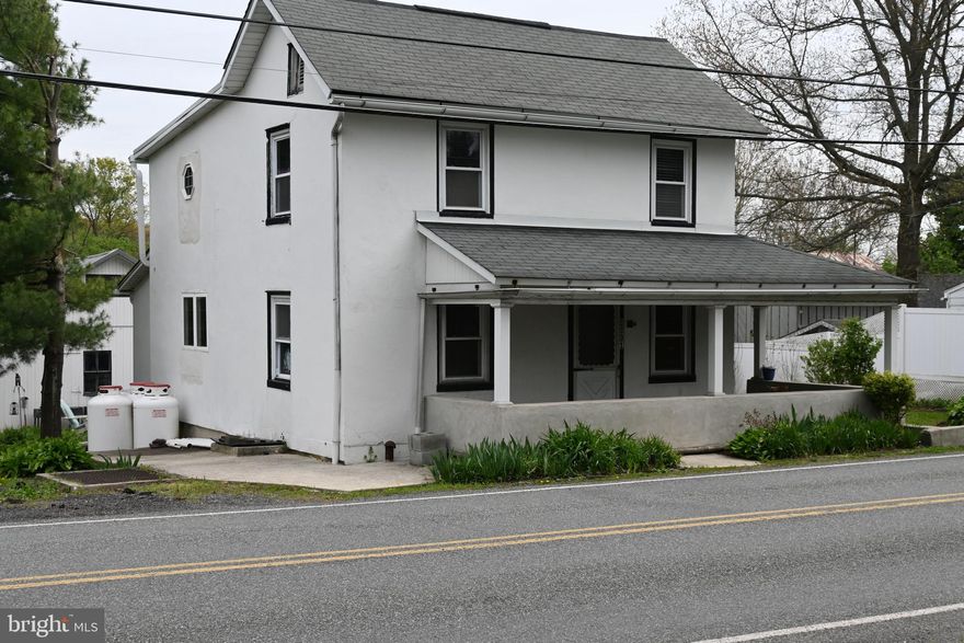 Attractive stucco home nestled in a small village within walking distance to post office, school and restaurant. Minutes drive to Pa turnpike and lots of walking paths in different parks in the area. Approximately ¾ of an acre gives you a country feeling with the property going all the way back to a creek.

Chefs will be delighted with this impressive kitchen. Quartz counter tops, gas cooking range & electric oven, microwave above and an upgraded refrigerator with two drawers and freezer can stay. Extra deep cabinets with convenient pull-out spice racks, pull out lazy Susan, pull out drawers, hidden toe-kick drawer, all with self-close features. Farmers sink with soap dispenser, stainless dishwasher, and a very spacious pantry. Under counter lighting for evening ambiance and recessed lighting on the ceiling.

Space is not stingy in the living room, which is large enough to share for a dining area, if you choose. Office on the first floor includes some shelving. Tiled floor entry to the first-floor full bath with a walk-in shower and vanity.

Double bowl vanity, jetted soaking tub surrounded by tiling, a window above the tub in this luxury second floor bath.  Skylight for moon light and an octagon window (which opens) for more ventilation.

 The third bedroom is currently used as a walk-in closet or dressing room. (The room could be used as a nursery.)   Walk-up attic for storage.

Basement has double bowl utility sink and washer and dryer hook-up.

Wrap around porch out front and an inviting patio in the back which separates the house from the garage/outbuildings. The patio is perfect for morning coffee or summer night relaxation.

18 x 65 exterior building with a metal roof, used to house the Spinnerstown butcher! Currently in the building there is garage space for maybe two cars, 18 x 26 home theater room, and 9 x13 kitchenette.  The finished living area in the building is heated with propane.   The theater room has tiled floor entry, two triple windows, high ceilings, and three ceiling fans.  The wall could house an approximately 100 inches screen. The room is wired for cable, speakers, and projector.  Closets, track lighting and evidence of the old butcher shop on the ceiling of the theater room. Kitchenette next door has an exterior door.   The original butcher cooler is still there!

Detached 12 x 32 car garage includes an 8’ garage door, loft above and garden shed in the rear of the building.  The back yard has two dog runs and yard all the way to the creek. Back-up generator on both the house and outbuilding. What a find!