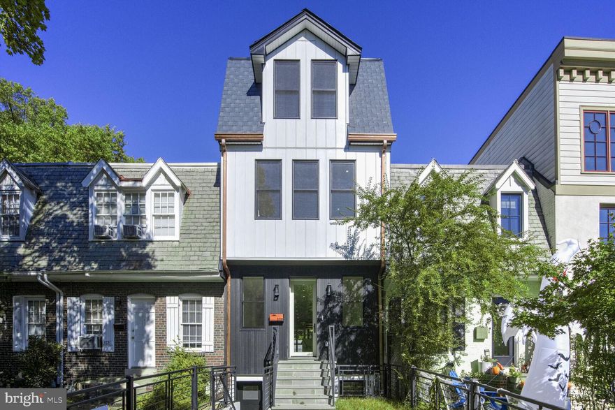 Welcome to the newest breathtaking Modern Addition to the Burleith Neighborhood! Five bedrooms, four and a half baths of modern luxury footsteps to Georgetown, and thoughtfully designed to accentuate the best use of the original footprint expanding it to new heights.

You are met with incredible curb appeal right away; a flagstone walkway with green front lawn tastefully surrounded by custom metal fencing, a gate, and a front entrance to the lower level.  The centered full light front door floods the front living room with light. The exterior is cantilevered with custom fluted siding, and James Hardie panels for both its textured appearance and maintenance free life. Copper downspouts and gutters hint at the elegant choices within.

The breathtaking open concept spaces start with 9 ft ceilings, Herringbone hardwood floors, and defined living spaces. The living room is simple and ample, connecting to the upper floors with expanded deep solid wood treaded stairs with custom metal railings. 

A centered Island kitchen is the heart of the first floor and the envy of any Gourmet Chef. Ample modern floor to ceiling wood cabinetry in honed gloss white, a kitchen island with offset natural wood cabinetry and a counter top and backsplash composed of double-edged quartz-stone. Stainless Viking appliances, 36 -inch six burner professional range, double oven with convection microwave and French door refrigerator round out the space. The island has seating for four with fluted wood accents and nook with hand cut cedar bench adding depth and additional modern design connections.

The entire rear of the house is a wall of glass, with floor to ceiling windows, and a wall of folding Nana doors that can make the large composite decking a direct extension of the living space when weather permits. A tucked in wine bar with wine fridge and accent walls finishes the rear dining and breakfast nook areas.

The second floor has the rear facing primary suite with floor to ceiling windows, a balcony, a wall of fluted wood cladding and custom designed dual walk-in closets. The ensuite bath features a double sink, massive walk-in shower in white herringbone marble, sliding glass shower door and pedestal soaking tub. The front bedroom is a mirror suite with double closets, and a fluted wood accent nook. The bathroom features custom herringbone Carrera, hung granite sink and soaking tub. The hallway features a side-by side front loading washer and dryer with butcher block top.

The third level suite opens to loft den with skylight and sliding door to an enclosed deck with a blue shiplap accent wall, cabinets, undermount sink and microwave. Steps from the deck lead to an additional massive enclosed roof deck with views of the roofs of Georgetown. Perfect for parties or watching the fireworks. Moving to the front is another oversized bedroom with soaking tub double sink dormer peaked ceiling, and custom cabinetry with bespoke cedar shelving and wall sconce lighting.

Custom squared recessed four-inch LED throughout the home. The first floor features blue tooth speaker sound systems, also found in the ensuite baths. There are custom perimeter vents for the dual zoned HVAC. The entire shell and between the levels of the house are closed cell blown insulation for comfort and sound. Instant hot water and engineered hardwood throughout. Windows all double hung, double thermal paned for elegance and function. Roof is TPO with deck panels and front Architectural Shingle.

The lower-level features exterior front and rear entrances is another living space, with sink, microwave and bar fridge. A large tiled bedroom graces the front and an additionally in the rear with full bath and washer and dryer. Perfect as a nanny space. The rear of the property is fenced, with greenery and a commercial roll up garage door and  two-car off street parking pad  with electric car charging plug. For the discerning buyer extraordinary craftsmanship make this a perfect choice.