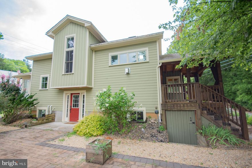 Nestled in the heart of Shepherdstown, beside Bane Harris park, you will find one of the most unique, and charming, home. It blends right in, in shades of green with a timber-framed front porch. Airy great room, with solid oak flooring, a cathedral ceiling, and light flooding in through skylights and windows. Galleried landing overlooks this space from the mezzanine level. Open seating area benefits from a propane gas fireplace. Well-appointed kitchen, granite countertops, wooden cabinetry, and electric appliances including an island w/built-in induction cooktop. The adjacent forward-facing bump-out, with a trim of Portuguese tiles, is surrounded by windows and allows comfortable dining, or a spot to sit and watch the wildlife.  Utility room is shielded by a handmade, cherrywood barn door. This space has porcelain tile floor and is pre-plumbed for a stackable washer & electric dryer. Hallway includes lighted display cabinet which forms an end cap on the extensive shelving. It divides the oak stairwell and provides storage and display space from the basement right up to the mezzanine level. Primary suite boasts a built-in closet, which features a "pass-through" designed to be large enough for a laundry basket to access the utility room. The oak floored room has elevated windows to allow ample light while maintaining privacy around the bed. A tiled sunroom allows for a perfect reading area, with multiple blinds to control the light and ensure privacy. The bathroom has built in wooden storage, a black quartz double vanity, and a tiled, curbless shower. Within the shower are two shower heads boasting a rain head and a standard fitting. The mezzanine floors are cork, providing both thermal and sound insulation. French doors lead to second bedroom with a skylight. A full bathroom, with tub, quartz vanity, & built-in linen storage is adjacent to this room. Entertainment level features 9' ceilings, stained concrete flooring, with insulation below, includes a Murphy bed and closet. Separate kitchen with a 2-ring gas stove, dishwasher & granite counter tops.  Spa bathroom w/jetted tub & quartz vanity. Soapstone-clad wood burning stove is in the center of the space and has a flue running through the full height of the house to the roof; this, together with a thermostat-controlled fan, allows the wood stove to distribute heat throughout the house. Concrete floor and the soapstone together act as a heat sink, warming the lower level long after the stove has stopped burning. Air inlet pipe for combustion air running beneath the floor to the wood stove. Electric mini-split air handling units on each level, and in the primary suite. Water passes through a manifold system with individual shutoffs for each faucet in the house. A propane tankless water heater allows for simultaneous use of multiple hot water systems. Laundry is available with a stackable washer and propane-fueled dryer. Whole house central vacuum. The ICF construction, combined with the 2x6 exterior wall construction with foam sheathing, spray foam skim coat, a layer of fiberglass batting, result in a very high degree of insulation. Exterior walls are clad in Hardy board, and the decking is a low-maintenance composite plank. An HRV system controlled from the hallway, brings fresh air into the living spaces and pumps stale air out of the bathrooms using a heat exchanger to compensate for the "air tight" nature of the house.  Large patio area, English cottage garden style and perennial plantings. Although these plantings are no more than 8 years old, this yard was featured on the Back Alley Garden Tour in 2023.  On street parking is allowed in this area, without a permit, but there is also parking for one vehicle on a gravel space from Queens Alley, in rear of the property. Easy walking access to Shepherd University, Wellness Center, and center of Shepherdstown. A short stroll across the bridge into Maryland gives access to the C&O canal.