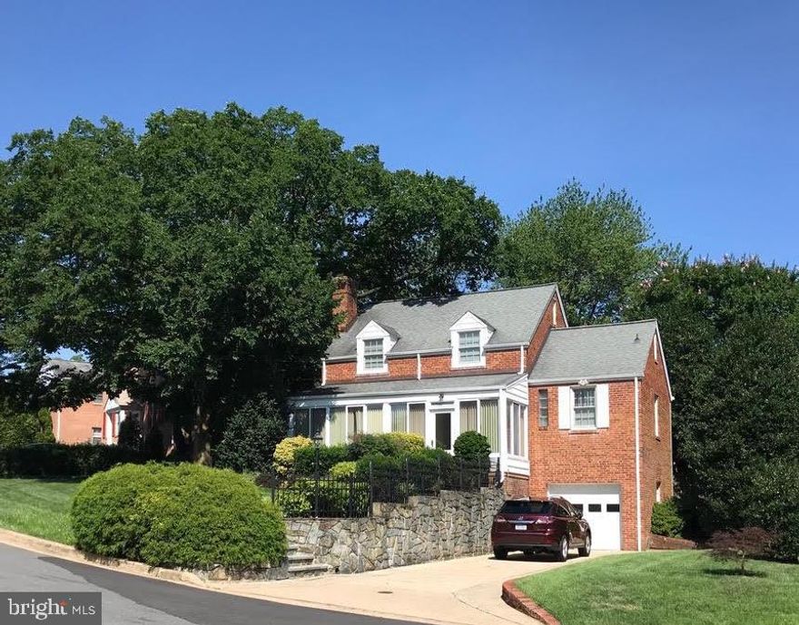 Loaded with Curb Appeal! Nestled in the Overlee Knolls neighborhood of North Arlington, this storybook Colonial proudly sits on a beautifully landscaped garden lot on high ground affording sweeping views over the picturesque streetscape. Offering 3 finished levels, 3 bedrooms, 2½ baths and charming dormer windows, this home exudes character and comfort. Step in through the glass-surround front porch sunroom into a warm and inviting interior featuring gorgeous hardwood floors, living room with a gas fireplace, separate dining room with period built-in cabinet, and an updated kitchen with a clever breakfast area that seamlessly connects to the patio and backyard. The step-up 3rd bedroom suite with full bath over the garage and exceptionally spacious upper level bedrooms and remodeled full bath are sure to please. This rarely offered model features bedrooms on multiple levels for added flexibility and privacy. The finished lower level presents a modern recreation room with recessed lighting and new LVP flooring plus a spacious utility room with workshop area, abundant storage, half bath, pleasant laundry area and super convenient attached garage. Enjoy peace of mind with young systems and many replacement windows throughout. Don’t miss the bonus storage space located under the sunroom! This home is sited on a generous 8,298 sq ft lot with professionally landscaped grounds, a beautiful masonry patio and gorgeous stone hardscaping. The prime location places you just around the corner from the quaint shops and restaurants of Westover, Overlee pool and swim club, neighborhood parks, the W&OD Trail, and only 5 blocks from the East Falls Church Metrorail station (Orange and Silver Lines). Come see why Overlee Knolls is so popular with today’s homebuyers!