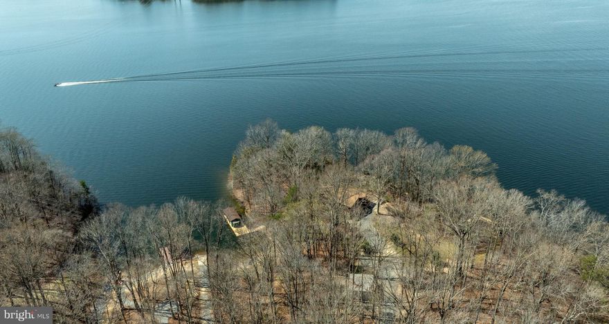 Rarely does an opportunity like this present itself.  A 2.2-acre point lot with  900' of rip-rapped frontage and a private sandy beach with no HOA. The classic log home cabin has 3 bedrooms and 2 baths on the main level, an oversized great room/kitchen/dining area and wood paneling and beams complete the rustic feel! View the lake from every window or sit on the porch and enjoy long lake views and beautiful sunsets. Downstairs is a partially finished basement with a large storage area/workspace. Outside it is a short walk to the boathouse with a single slip and lift, the shared boat ramp, the private sandy beach, or the fishing pier! A detached 2-car metal garage and a wooden storage shed complete this private escape.