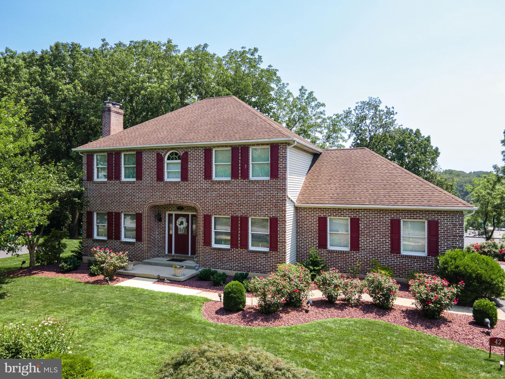 Welcome to this stunning 3-bed, 3.5-bath brickfront colonial nestled in prestigious Hillcrest Acres. North-facing home with sunny southern exposure in the rear *NEWER ROOF & A/C UNIT!* French drs open to a den/study/office w/wall-to-wall shelves & ceiling fan. The bright FR feat 2 ceiling fans, cozy brick fireplace w/mantel & sliding dr access to the walkout deck. The kitchen & eating area feat tile flrs, charming bumpout window, granite counters, recessed lts, ceiling fan, matching bisque apps & ctr island w/bfast seating. A 1/2 bath & laundry rm complete the 1st flr. Upstairs, HW flrs continue throughout. The spacious master ste boasts a ceiling fan & his/hers walk-in closets. The luxurious en-ste bath inc tiled flrs & walls, palladium window above the soaking tub, a tiled walk-in shower w/glass dr & dual sinks. 2 add'l nicely sized bedrms w/ceiling fans share a full bath w/tiled tub/shower combo. The fully finished walkout basement expands your living space w/LG rec area feat wall-to-wall carpet, gas fireplace, recessed lts, charming bumpout window w/bench seating, built-in wall bench, full wet bar & full bath w/walk-in shower. Step into the enclosed patio w/tile floors, stacked stone accents & ceiling fans—an ideal space for year-round enjoyment. The manicured backyard backs to mature trees for added privacy. A 2-car garage w/paved driveway complete this exceptional home. Close to major hwys US-22 & PA-33 for easy commute, Green Pond C.C, shops, restaurants & more!