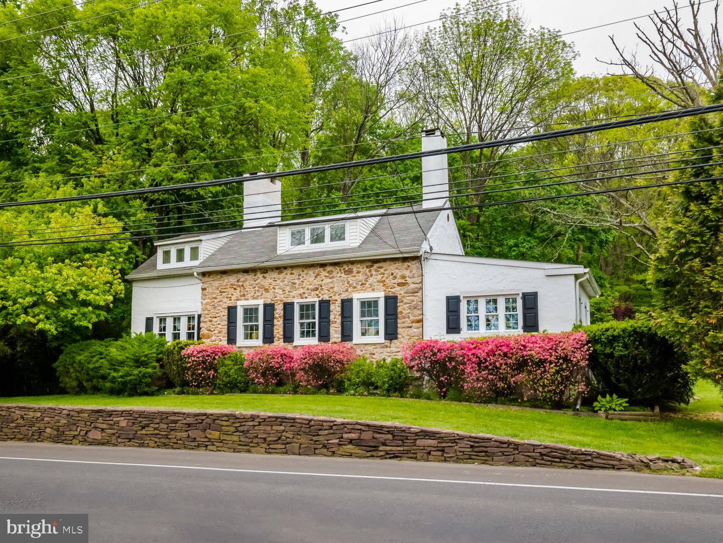 Founded on over two acres this 1840's restored, and renovated farmhouse has maintained all the charm of an era gone by while incorporating the modern amenities of today. A detached workspace offers its own deck with pergola. The main house includes three bedrooms, two full baths and a large patio that enjoys a lush view. The tiled sunroom affords the original stone wall and an energy efficient wood-burning stove as the vaulted ceiling with skylight and exposed beams creates a very inviting appeal for family and friends. Deep-silled windows bring in the colorful landscaped views and a Dutch door gives you direct access to the kitchen. With the rich hardwood floors, built-in shelving units, numerous windows and the walk-in fireplace with mantle the formal living room is an ideal conversational area. Notice the original doors with latches, one is a pie-stairwell leading upstairs, the other takes you to the dining room. With the character of the exposed beams, the hardwood floor and faux fireplace, guests will feel enchanted when dining in this charmed room. A large eat-in kitchen is the heart of the home regardless of which century you live in. This bright and airy kitchen is no different. A custom barstool table provides casual seating, stone counters that stretch up the backsplash to the cherry cabinets and a seamless sink donning dark bronze fixtures including sprayer and soap dispenser. The first-floor master suite is flush with built-in cabinetry, enjoys the extra spaciousness of a raised ceiling, brings in the pretty green views and has a private bath with step-in shower. The unique stairwell gives the two bedrooms upstairs a sense of privacy with their own hallway. Each room has its own character with the architectural lines meeting the banks of windows that bring in a sunny ambiance. There is also ample closet space and a shared full bath. An amazing space, the original outbuilding with wood burning stove gives you the opportunity to have an inspiring art studio, home office or a workshop that could be the ultimate man cave, let your imagination soar. A brand-new septic system was installed in May of 2019, there's extensive parking, you are in the nationally ranked Central Bucks School District plus are central to Newtown, Doylestown and New Hope. Don't miss out on this charming home!