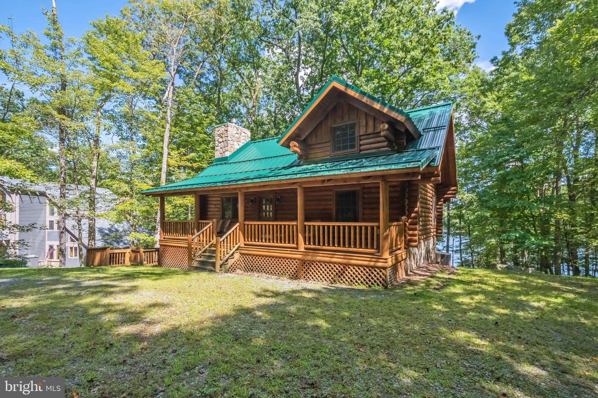 Cozy lakefront log cabin with private Type A dock! Metal roof ( 3 yrs old), post & beam interior, gas fireplace and impressive lake view sitting area that was built as an addition. Offering 120+ ft of waterfront and the buydown has been purchased & completed. Impressive location on the water with wider lake views and views of the 219 bridge in the distance. Full, unfinished basement offers additional space for expanded living area, additional bathroom, storage. Other features include an EV charger, quiet front porch surrounded by mature trees - very private feel with massive boulders and a very low maintenance yard. Conveys with most furniture and contents.