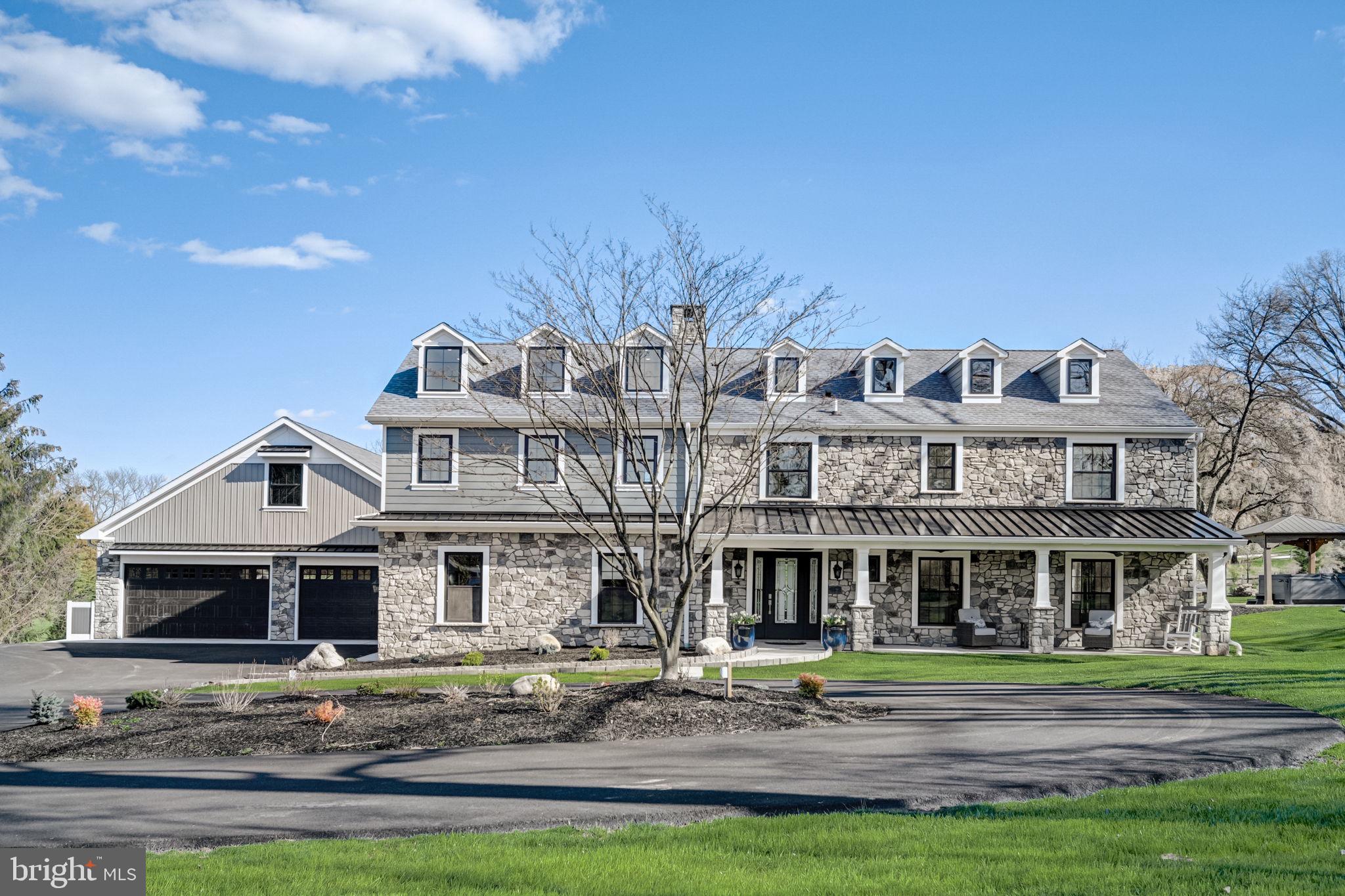 Introducing 5172 Militia Hill Rd – a stunningly rebuilt 4-bedroom, 4-bathroom home in Plymouth Meeting, nestled on a prized 2.3 acre lot overlooking Sunnybrook Golf Course. This property boasts a fully fenced perimeter, gated entrance, and circular driveway for added allure. Crafted with a blend of stone and Hardie-board exterior, complemented by sleek black windows, this residence seamlessly marries timeless elegance with contemporary flair.
Inside, discover an expanse of wide-planked white oak flooring throughout. The airy open-concept layout showcases a spacious great room adorned with a welcoming fireplace and dual glass doors framing picturesque views. The heart of the home lies in the kitchen, featuring a sprawling center island, bespoke beverage bar, and butler area, all accented by quartz countertops, marble backsplash, and gunmetal appliances. An adjacent dining room seamlessly connects to the great room, ideal for effortless entertaining.
The main floor also hosts a mudroom, a full bathroom, and an expansive home gym. A breezeway links the main house to the 1,840-sq ft garage with finished loft. Ascend the modern staircase to the second floor, where the primary suite awaits, complete with a tray ceiling, customized walk-in closet, and luxurious full bath featuring an oversized shower. Two additional bedrooms share a beautifully appointed hall bathroom, while a second ensuite bedroom offers convenience and privacy. Next to it is a versatile loft with a kitchenette, and a staircase leading down to the home gym.
Outside, revel in the meticulously landscaped grounds featuring a sprawling paver patio, perfect for both sunbathing and outdoor dining. A charming gazebo with a hot tub and a centrally located fire pit offer additional relaxation and entertainment spaces. With all-new mechanical systems including 3 HVAC zones, a brand-new septic system, and electric car charging capabilities, this home is move-in ready. Embrace a resort-like lifestyle at 5172 Militia Hill Rd – your everyday escape awaits!
