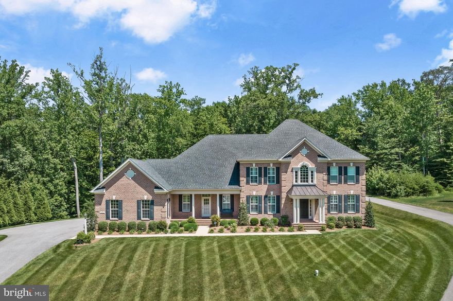 609 Churchill Circle is a magnificent estate in the coveted neighborhood of Governors Reserve that leads with its stately curb appeal, grand entertaining spaces, considerable private quarters, and countless upgrades. Perfectly situated on 5.61 acres on a quiet cul-de-sac, this unforgettable property offers well-curated living spaces with sophisticated moldings, lofty windows, plantation shutters, soaring ceilings, hardwood flooring, generous room sizes, custom design-inspired upgrades, an outdoor oasis, and so much more. The grand foyer is a breathtaking welcome, catching your eye immediately with its second story ceiling, sidelights, transom window, and wide-set staircase. Anchored on either side of the foyer are the formal living and dining rooms, two wonderful entertaining areas well-suited for celebratory events. Inspire your inner chef in the gourmet kitchen appointed with quartz counters, large farmhouse sink, subway tile backsplash, white 42-inch cabinetry with under cabinet lighting, a contrasting expansive center island with substantial stacked edge counter, and high-end stainless steel KitchenAid appliances including a gas range and wall oven. The kitchen also highlights imported Italian tile flooring, two walk-in pantries, and a casual dining area with butler’s pantry. The adjacent sunroom showcases a cathedral ceiling and beautiful Palladian windows. Sure to impress, the family room is a bright and comfortable room that has been outfitted with a striking stacked stone fireplace, making it the perfect venue for spending time with loved ones. Further, the main level offers a friends and family entrance providing a mud room with board and batten trim, built-in hall tree, and garage and laundry room accesses. Laundry is a breeze with storage cabinetry, folding counter, and utility sink. Finally, work from home with ease in the main level home office characterized by French doors. 
The substantial upper level can be accessed by either of the two staircases and is an exciting collection of 4 bedrooms and 4 full baths, with an interior balcony overlooking the foyer. Retreat to the primary suite that is graced by a tray ceiling, sitting room, and walk-in closet with California Closet system.  The spa-like primary bath showcases an expansive double vanity, a soaking tub, and separate floor-to-ceiling tiled shower. Three additional bedrooms, each of a generous size, with an attached full bath concludes the upper level. 
The sprawling walk-up lower level presents a sensational recreation room and media room with shiplap accent wall, wood-look ceramic tile flooring, and a kitchenette with stainless steel refrigerator, granite counter and bar seating. The lower level also offers a bonus room, an expansive exercise room with floor-to-ceiling mirrors, and a full bath with barn door tiled shower making it ideal for entertaining or for use as a guest suite.  
Enjoy the fabulous outdoor spaces that will easily allow you to host the best outdoor gatherings as well as rest and relax with features including the exquisite brick paver patio, composite deck, inground heated saltwater pool with automatic cover and PebbleTec finish, as well as a hot tub overlooking the fenced backyard and mature trees beyond. Additionally, exterior features include landscaping designed by a landscape architect, Japanese Maples, Crepe Myrtles, 2 zoned exterior lighting system, irrigation system, and a side-loading 3 car garage with attached storage shed. 
For convenience, this property also offers an architectural shingle roof with upgraded gutters, upgraded zoned HVAC with 3 zones (main level 18 seers, upper and lower levels 15 seers), concealed interior sprinklers, upgraded carpeting, ample closet space, 2 sump pumps, a backup generator servicing 75% of the home, main, lower level &outdoor speakers, and a monitored 1,000 gallon propane tank. This remarkable property aims to please and is truly the embodiment of Maryland’s good life!