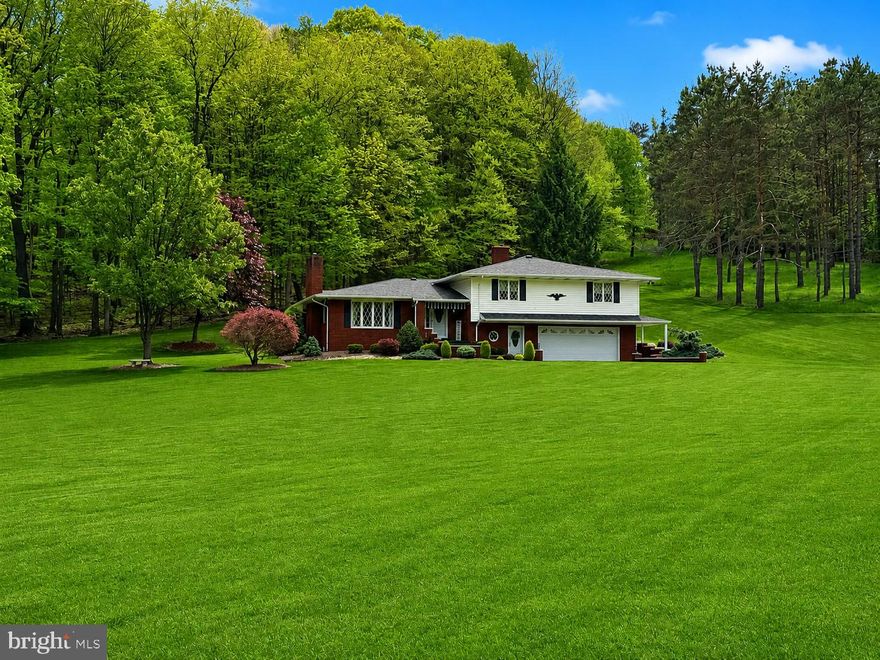 Tucked away on 3.82 beautifully maintained acres on the outskirts of Frostburg, this exceptional split-level offers the kind of setting buyers dream about—peaceful, private, and surrounded by nature, yet just minutes from town conveniences. Backing to woods and framed by immaculate landscaping, this property immediately reflects the care and pride that have gone into every inch of it. From the moment you arrive, you'll feel it—this is a home that has been truly loved. Inside, you'll discover warm hardwood flooring and a stunning custom kitchen designed to be the heart of the home. Offering 3 bedrooms and 2 bathrooms, including a spacious primary suite with an attached Jack & Jill bath, the layout is both comfortable and functional. Downstairs, the massive rec room creates the ultimate gathering space with a beautiful stone fireplace, an impressive built-in bar, and room to host everything from holiday celebrations to game-day get-togethers. The oversized laundry room offers exceptional storage and workspace, while an upper-level hobby room presents an easy opportunity for a future additional bathroom if desired. Comfort and efficiency are front and center with central A/C, public water and sewer, a two-car garage, and a rare four-source heating system featuring a heat pump, oil boiler, coal boiler, and propane fireplace. Properties that offer this level of care, flexibility, acreage, and setting are few and far between. This isn't just a house—it's the kind of place that feels like home the moment you pull into the driveway. This one is a MUST SEE!