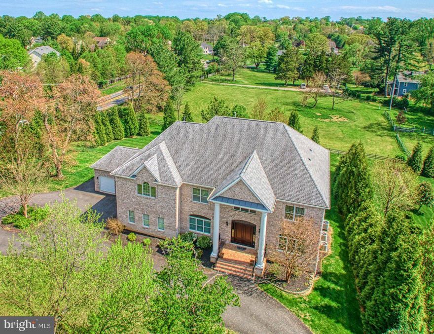 Fabulous, custom, all-brick colonial with amazing architectural details on all three levels.   Stunning moldings, tall ceilings, hardwood floors, built-in cabinetry, wainscoting, top-of-the-line windows, crafted doorway framing and more in this gorgeous over 9,000 sq.ft. home by ASTA Homes.  You and your guests will be warmly greeted by a circular driveway and covered brick front porch.  Inside, you’ll fall in love with the grand wooden curved staircase with wrought iron balusters and two-story foyer.  This wonderful home, sited on a slight knoll overlooking the meadow behind it, has inspiring southern views of vintage Oakton open space.   The grand gourmet kitchen has beautiful solid cabinetry, stainless steel appliances and a large island with bar stool seating.  There is a six-burner gas cooktop with griddle, a wall oven, a warming drawer and an extra-wide side-by-side built-in refrigerator.  There is recessed lighting, chandelier lighting and sleek quartz counters.   The family room, off the kitchen, has a gas fireplace surrounded by built-in shelving and has a wall of windows and doors looking south over the private, sunny, acre-plus yard below.  The ten-foot ceilings and hardwood floors throughout the main level are only surpassed by the classic coffered ceiling in the dining room and all the moldings and sconces in both the living room and dining room.   There is a versatile office/library area that nicely serves as a fifth-bedroom, multi-generational suite, with its own full bath and walk-in closet.  There are four bedrooms upstairs, plus a second office, and a large laundry room.   Each of the bedrooms has its own full bath, walk-in closets, linen closets, hardwood floors and crown molding.  The luxurious primary suite has a sitting area, nine-foot ceilings, a tray ceiling, dual closets and a gas fireplace with marble hearth.   The sumptuous primary bath has a Kohler whirlpool tub, a separate shower with clear frameless glass door, dual sinks, porcelain floors and recessed lighting.  Is this home luxurious or what!!!  The lower level continues the same quality as the upper two levels.   It has windows across the entire rear of the home and a fabulous walk-out recreation room with French doors to the patio.  There is a gorgeous bar with sink, full-size refrigerator, dishwasher and barstool seating.  There is the sixth bedroom with its sixth full-bath and also a handy office for work-from-home days.  The home is equipped with three high-efficiency HVAC units serving each floor independently, a gas hot water heater, an ERV/HRV air exchange system (for heat and energy recovery,) and 2X6 wall construction.  There is an unfinished area perfect for a home theatre.  The extended dual two-car garages have bonus areas perfect for outdoor tools and equipment, so it’s like having a four-and-a-half-car-garage.  The home is “elevator ready” to all three floors and sellers will consider working with buyers on the installation of an elevator.  There is a mudroom with cubbies off the garage entries and many hidden closets and storage areas.  There is no HOA!!! This outstanding home on this beautiful acreage, near the Town of Vienna, Tyson’s Corner, the I-66 corridor and Oakton shopping, offers some fortunate buyers years of comfortable, gracious, care-free living.