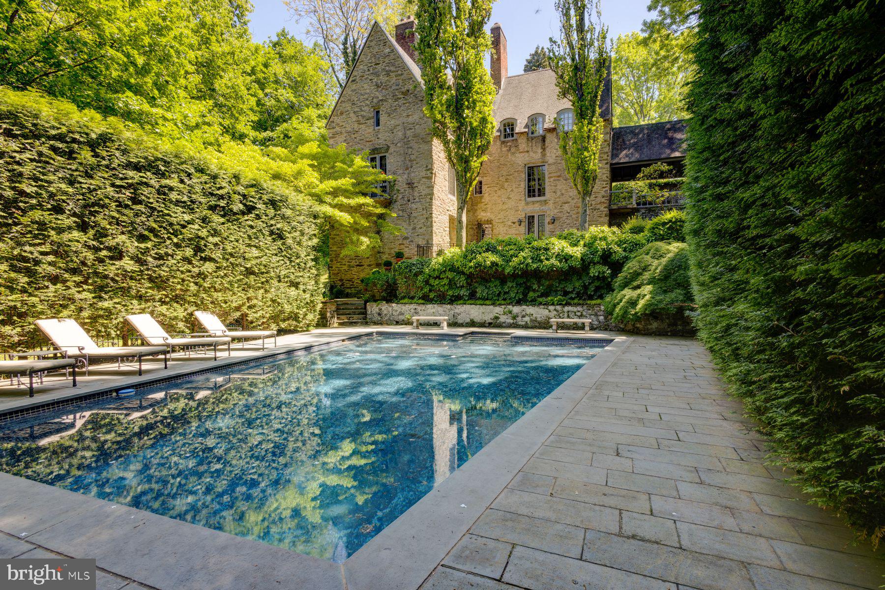 Step into a rare piece of architectural history in this distinguished home sitting high above the scenic trails of Fairmount Park’s Wissahickon Creek and within walking distance of Germantown Avenue.
This extremely private house designed by George Howe of Mellor, Meigs & Howe and built in 1921 offers Old World architectural charm and elegance coupled with New World amenities. This highly coveted architect was known for designs that emphasized craftsmanship, integration with natural landscapes, and human-centered functionality. This property reflects all these design elements and has been lovingly and diligently restored and updated over the past twenty years by the current owners. In fact, in over 100+ years, this house has had only 4 owners - a reflection of the comfort, ease and splendor of living in this highly functional architectural marvel!
A showpiece of elegance and style, this 4,250 square foot Norman-style residence sits on a lush .47-acre lot surrounded by mature trees and lush gardens. While it is statuesque in size, its presence from the street is subtle as it is nested into the hill by a series of outdoor garden rooms that open up to the distant landscape exposing its grandeur. A beautiful swimming pool anchors the vista in this serene setting. The seamless relationship between the outdoor spaces and the interiors creates a very private and comfortable living environment.
The Wissahickon schist stone exterior of the house and integrated retaining walls further reinforces the relationship between the house and the site. The steep roofs, soaring chimneys and diverse dormers are key features of the architecture.
This four-story house is designed such that most of the rooms have three exposures creating a light-filled interior with multiple views. The perfectly sized living and dining rooms each have a working fireplace, floor to ceiling windows, and French doors that open to the gardens overlooking the valley below. Adjacent to the formal living spaces is an eat in kitchen with butler's pantry and bar area, a powder room, and a large family room. On the lower level is a media room, office/painting studio, separate laundry room with adjacent half bath, and shop.
The second floor has three large bedrooms, two with working fireplaces, each with ample closet space, and two full baths. The top floor has a large suite with full bath, connected seating area, walk-in closet and balcony.
For the discerning homebuyer, 95 W. Hampton Road in Chestnut Hill is not to be missed. This house is not only an architectural masterpiece, it is fully updated and move-in ready and walking distance from the shops and dining on Germantown Avenue in Chestnut Hill, the Woodmere Art Museum, the Morris Arboretum and the trails of Fairmount Park. Come see for yourself one of Chestnut Hill and Philadelphia’s finest homes that rarely comes to the market!