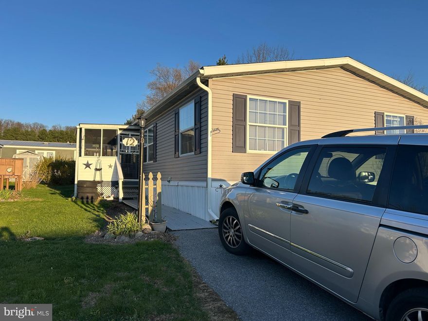 Nice comfortable manufactured home with 2 bedrooms and 2 full bathrooms. An open floor plan of living room and dining room with doors that lead to a newly constructed deck, 2025. There is an enclosed porch to the main door and a 2-car parking area.  There is a detached shed for storage. The kitchen is a bright eat-in kitchen. Shed has a new roof. Buyers must be approved by park.  Listing agent is related to owner.