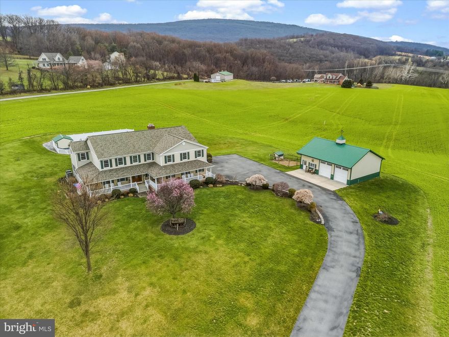 Texas farmhouse‑inspired estate set on 8.73 picturesque acres in Boonsboro, offering sunsets over expansive mountain scenery tucked among rolling pastoral views. With 3,553 sq ft above grade plus a fully finished walk‑out lower level, this home blends scale, warmth, and extensive infrastructure upgrades for everyday comfort, entertaining, remote work, and long‑term flexibility.

The main level features a traditional living room and formal dining room flowing alongside the well‑appointed kitchen with granite countertops, generous workspace, double oven, gas range, under‑cabinet lighting, GE SmartHQ appliances (2023), and a dedicated dry pantry with upright freezer. These spaces open to a dramatic two‑story family room with fireplace, ideal for entertaining and family gatherings, framed by expansive windows capturing scenic mountain and sunset views. Wide‑plank LVP flooring (2021–2022) enhances all main living areas, while wall‑to‑wall carpeting provides comfort in the bedrooms.

Upstairs offers four bedrooms, including a spacious primary suite with walk‑in closet, updated bath with soaking tub, and dedicated HVAC zone. One guest bedroom includes a walk‑in closet convertible to a small craft area or private office. All bedrooms feature lighted closets. The upper‑level laundry room includes GE SmartHQ front‑load washer and dryer (2022). In total, the home provides 3 full baths and 1 half bath.

Interior features include two fireplaces (one upper level, one lower level) with updated inserts and stainless steel flues, Trane HVAC systems under 8 years old with multi‑zone controls for main and upper levels plus a separate primary suite zone, 28 newly replaced double‑hung windows (DP50 R‑PG40, vinyl frames with screens), central vacuum, whole‑house intercom and music system, recessed lighting, custom closet organizers, and integrated smart‑home wiring.

The fully finished walk‑out lower level with wood stove includes a second kitchen, recreation room, full bath, storage, and direct access to an expansive concrete patio.

Outdoor living is exceptional, with brick walkways to a 24,000‑gallon in‑ground pool (graded 3–8 ft with entry steps and jumping board) featuring a new 27‑mil liner (02/2024) and new Hayward H‑Series 400K BTU heater (02/2025), pool house, new outdoor hot tub, outdoor surround sound, and a block‑built fire pit for bonfires. Enjoy a wraparound porch with cement base and a refurbished deck overlooking panoramic mountain and pastoral sunsets.

A blacktop driveway leads to a side‑load 2½‑car garage with EV charging. The detached Extreme™ outbuilding (approx. 30'×40'+) offers two tall‑bay doors, heat, water, cable, phone, concrete floors, and an insulated 13.5'×11.6' office with heat and A/C, plus floor‑to‑ceiling storage with library ladders.

Infrastructure includes a new 2023 CertainTeed Landmark Pro architectural roof (130‑mph) with SureStart PLUS coverage through 04/14/2073 (fully transferable), 500‑amp electric, generator hook‑up, water softener and water filtration plant, robust internet wiring, and a 500‑gallon LP tank (new regulators 2025) supplying heat to the home and pool. Grounds include fencing, high‑ and low‑voltage lighting, retaining walls, landscaping, and a chicken coop with electric. Potential subdivision (buyer to verify with Washington County). Convenient access to I‑70, I‑340, I‑9, and I‑81; near Appalachian Trail, historic destinations, VA/MD wineries, and approx. 60 minutes to IAD and BWI. Boonsboro schools. Positioned for both privacy and connectivity, this property supports full‑time residence, multi‑generational living, professional remote work, and long‑term investment potential while maintaining a rare balance of openness, security, and enduring rural character. This setting offers year‑round enjoyment, unmatched privacy, and exceptional flexibility for evolving lifestyle needs, ideal for today.