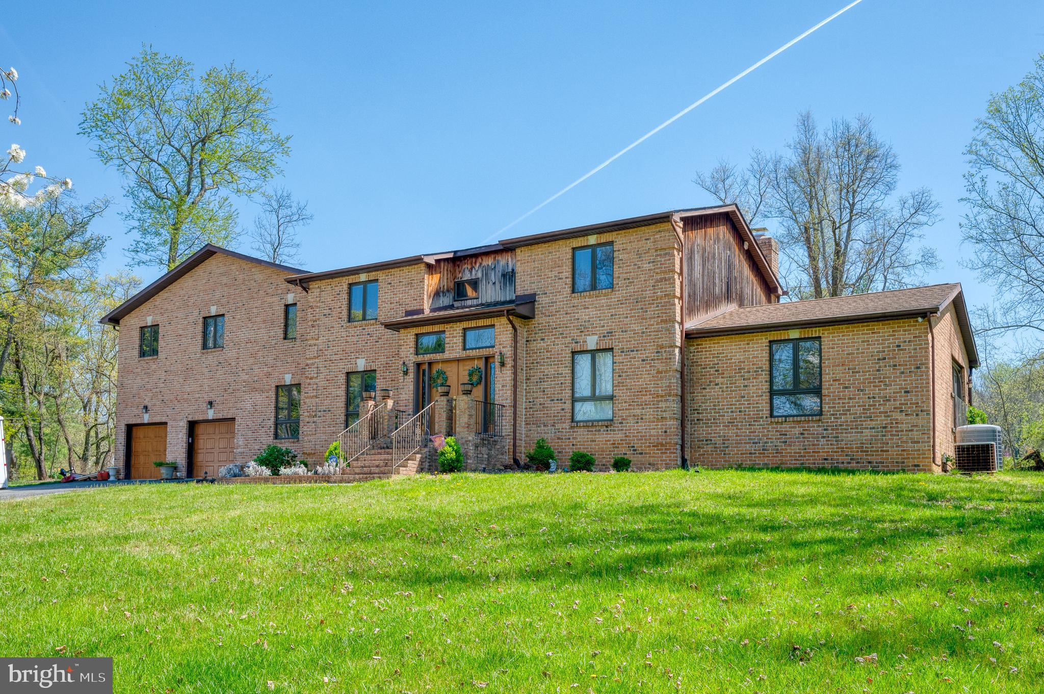 This stunning custom-built brick home is located on a desirable 1.38-acre private wooded corner lot in the highly sought-after neighborhood of Hickory Hill. Boasting 5700 square feet of living space, this home features five spacious bedrooms and 3.5 bathrooms, making it perfect for those who love to host guest and entertain. As you enter through the foyer, you are immediately greeted by the formal living and dining rooms, which are adorned with elegant hardwood floors that flow throughout the main level, adding a touch of sophistication to the space. The gourmet kitchen is a chef's dream, featuring granite countertops, a large island with a breakfast bar, recessed lighting, and ample cabinet space, making it perfect for preparing meals for family and friends. The adjacent dining area leads to the cozy family room, where you can relax and entertain guests. The entry-level primary suite offers a private oasis, complete with a spacious bathroom that features a shower, soaking tub, and dual vanity sinks. The upper level of the home features an expansive loft area overlooking the bright and airy oversized sunroom, adding an extra layer of comfort and luxury to this already impressive home. The outdoor living area is just as impressive, with a large patio area and a spacious backyard that is perfect for hosting barbecues and outdoor gatherings. This home truly is the perfect blend of comfort and luxury, and with all of its fantastic features, it is sure to exceed your expectations.