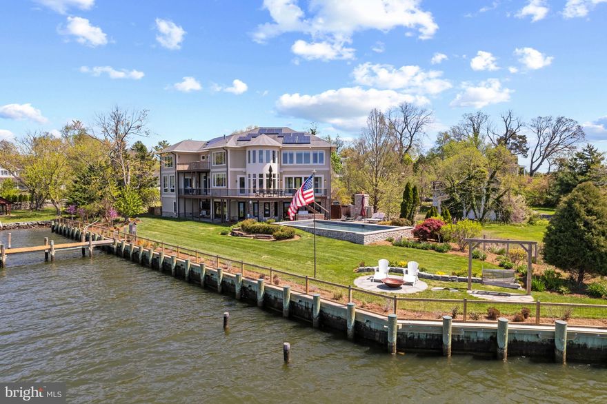 Experience the ultimate waterfront lifestyle in this exquisite home with saltwater pool nestled along the picturesque South River, offering breathtaking views that stretch as far as the eye can see. With the added convenience of an elevator, every corner of this residence is easily accessible, ensuring both luxury and practicality. Step into what feels like the bow of a ship as you enter the main living area, where sunlight floods through the windows, illuminating the space with warmth and tranquility and the awe-inspiring view reveals itself. The heart of the home is the chef's kitchen, equipped with top-of-the-line appliances and elegant finishes, perfect for culinary enthusiasts and casual chefs alike. An entertainers paradise, the main level floor plan flows easily from the spacious Living room/kitchen combo, to the open dining area with water views, wet bar and spacious family room with projection screen; perfect for gatherings of all sizes. There's even an office with a view! Retreat upstairs to relax and unwind in the primary suite, a serene oasis boasting a sitting area and a private balcony that overlooks the sparkling pool and tranquil waters beyond. Imagine waking up to the gentle sounds of the waterfowl and wildlife and enjoying your morning coffee with panoramic views of the river. Venture downstairs to discover the enclosed lower porch, a versatile space that seamlessly blends indoor and outdoor living. Whether you're hosting gatherings or seeking a quiet escape, this inviting area offers the perfect ambiance for every occasion. Outside, the waterfront oasis awaits, beckoning you to bask in the beauty of nature. Head out to the private pier with boat lift and multiple large vessel slips; a boating enthusiast's dream. Lounge by the poolside, savoring the cool breeze and the soothing sound of water lapping against the shore. As the day draws to a close, gather around the fireplace on the waterside patio and watch in awe as the sky transforms into a canvas of vibrant hues during the enchanting sunset. Welcome home to your own private paradise on the South River.